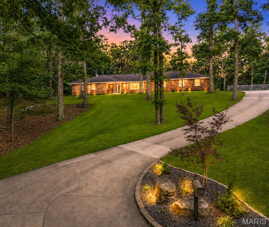 Tucked away on 2.14 wooded acres, this extensively updated home offers a setting that's hard to find. It feels like you're out in the country while still being just minutes from shopping, restaurants, and schools. The mature trees and wooded surroundings provide a level of privacy that's uncommon for an in town property.
With 4 bedrooms, 3 full bathrooms, 2 half bathrooms, and laundry hookups on both the main level and in the basement, there's plenty of room for family, guests, and entertaining. The main level features a spacious family room, an informal sitting room, and a large formal dining room. Brazilian teak flooring, custom Beussink cabinetry, granite countertops, and quality finishes can be found throughout.

Just off the family room is a finished four season sunroom complete with a mini split, wet bar, sink, mini refrigerator, hood fan, and gas hookup for grilling. Step outside to the composite deck overlooking the wooded backyard or relax on the new paver patio with a fire pit. The landscaping has been professionally redesigned by Bloomfield Landscaping and completes the outdoor living space.

The primary suite includes a beautifully remodeled bathroom with a tiled glass shower, freestanding soaking tub, double vanity with granite countertops, and custom Beussink cabinetry.

The walkout basement adds even more living space with LVT flooring, a projector for movie nights, built in shelving, a fun climbing wall nook for the kids, a kitchenette with sink, cabinetry, and pantry, abundant storage, and a second set of laundry hookups.

Recent improvements also include new windows, new front and rear entry doors, an oversized sliding glass door, remodeled bathrooms including a main level laundry room/bathroom, a heated and cooled garage with a floor drain, an expanded driveway with room for an RV, raised garden beds, retaining walls, and extensive landscaping.

Homes like this don't come on the market very often. If you've been looking for privacy, quality updates, and a home that's truly move-in ready without giving up the convenience of being in town, this is one you'll want to see. Please see the listing supplements for a complete list of updates and improvements made by the current owners.