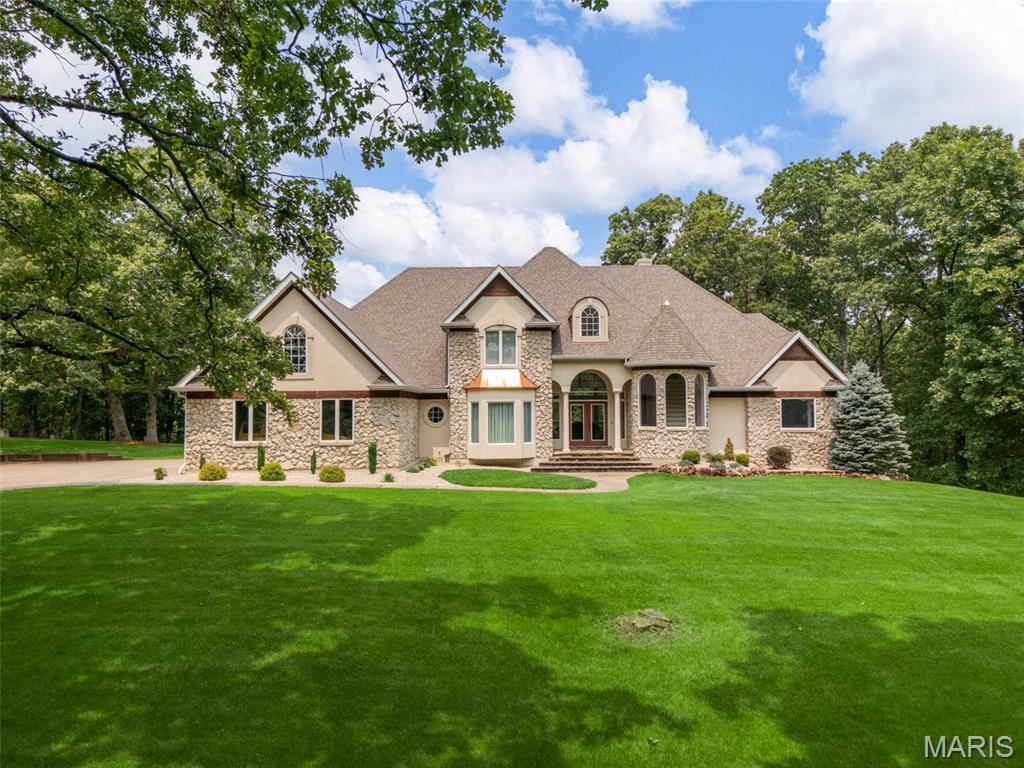 Motivated seller! Discover the perfect blend of luxury, privacy, and outdoor living within this 18 acre custom built estate! Tucked into a wooded, park-like setting, this fabulous story and a half home overlooks your own 1.5-acre private lake, stocked for fishing and ready for paddle boarding and kayaking. This home features an inviting open floor plan centered around a soaring 2 story great room with an impressive window wall that fills the home with beautiful natural light. The elegant foyer greets you as you enter the home, the large kitchen overlooks the cozy hearth room and great room making entertaining and enjoying the views effortless. The main floor owner’s suite features a spacious luxury bath, private entrance to the deck and walk-in closets. The 2nd floor offers 3 more generously sized bedrooms a beautiful balcony overlooking the great room and 2 full baths. Enjoy evenings entertaining or relaxing on the expansive deck, perfectly positioned to take in sunsets over the water. The walkout lower level is designed for guests and recreation, complete with a 2nd kitchen, spacious rec area, bathroom & potential for a 5th bedroom. Car enthusiasts and hobbyists will love the convenience of the 2 car garage plus 40’ x 60’ insulated workshop which offers 3 more garage bays, 10' doors & concrete floors. All of this is less than 10 minutes from Hwy 70 & Hwy 61: offering peace and seclusion without sacrificing convenience. This is a rare opportunity to own a private lakefront retreat with room to live, work, and play! Must have lender preapproval. 
Virtual tour: https://vimeo.com/1176676298?share=copy&fl=cl&fe=ci
