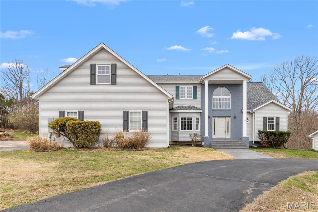 OPEN HOUSE: Saturday June 27th 11-1 & Sunday June 28th 2-3:30! Welcome home to this beautifully renovated 6 bedroom, 6 bathroom retreat nestled within nearly 3 acres of mature, wooded privacy. From the moment you arrive, the warm and welcoming open layout draws you in with soaring vaulted ceilings with exposed wood beams, rich warm-toned trim, and slate-toned tile floors flowing throughout. Two fireplaces anchor the living spaces, creating that cozy, come-as-you-are feeling that makes this home truly special. The lot features about 600' of frontage to the pond, offering beautiful view during your morning coffee to wrapping up the day watching the sunset over the water. The state-of-the-art kitchen is a showstopper, featuring dark granite countertops, a herringbone tile backsplash, stainless steel appliances, a large island with seating, and a charming breakfast nook giving you everything you need to cook, gather, and entertain. Oversized bedrooms offer generous space and comfort throughout, while the stunning primary suite serves as its own private escape with vaulted ceilings, French doors to the rear deck, a marble-look soaking tub, and a frameless glass shower. First floor laundry and 2 new HVAC systems and new furnace keep everyday living effortless. Head downstairs to the fully finished walkout basement, complete with a full wet bar, rec room, family room, a private bedroom and full bath. All opening directly to your finished backyard and sparkling inground pool. The main floor wraps to a full walk-around deck across the entire rear of the home, where wooded views and fresh air make every morning feel like a getaway. Fullfilling the car lovers dream, the detach garage is built to match the home, featuring a built in car lift, skylights, gables, a wood burning heater, eletric, and a concrete foundation. Accommodating up to 7 cars, the opportunities are endless with this rare find just steps away from the house.  This home beautifully blends timeless luxury with a warm countryside appeal that simply cannot be replicated. And HOA fee is voluntary for road dues.