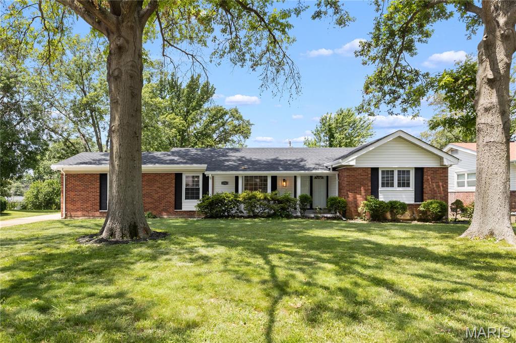 Remarkable 3-bedroom, 2-bath All-Brick ranch home with 2 car rear-entry garage, large lower-level bonus room, and over 2,100 square feet of livable space, located on a quiet, tree-lined street in the oh so popular Paddock Estates subdivision in Florissant, MO. Move-in ready with tremendous curb appeal, this home welcomes you with beautiful luxury vinyl tile flooring throughout and large picturesque windows offering plenty of natural light. The custom kitchen boasts 42-inch white shaker cabinets, a center island, and an open layout flowing seamlessly into the spacious family room with recessed wood-burning fireplace. The main level features a stylish hall bath, three generously sized bedrooms, which includes a primary suite complete with his-and-hers closets and an exquisite ensuite bathroom. Notable updates include a new roof, newer windows, and 200-amp electric service. The lower level offers a large recreation/game area, bonus room, utility/laundry space, and ample storage. Outside, enjoy a nice sized covered patio and large backyard perfect for the trampoline you’ve been promising the kids this summer! This home has everything you can imagine—the only thing missing is **YOU!**