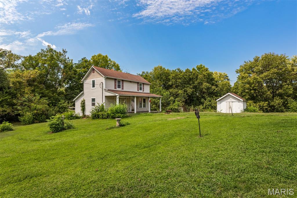 Country living with this 2 story home on a little over an acre of property offering 3 bedrooms and 1.5 bathrooms. Large front covered porch leads you to a large living room to your left and a formal dining room to your right with a brick surrounded wood burning stove placed nicely between the two rooms creating a cozy space. The living room boasts a huge front window to bring in tons of natural light and wood flooring with stairs leading to the upper level. The formal dining room is conveniently located next to the spacious eat-in kitchen that offers beautiful wood cabinets and plenty of counter space. There is plenty of room for a breakfast table or add a nice coffee bar. Just past the kitchen is a nice-sized mud room and main floor laundry area with an exterior door leading to the back yard. Completing the main level is a large den perfect for a home office, library or extra storage space with a convenient half bathroom. Upstairs you will find a master bedroom and 2 additional huge bedrooms along with a full bathroom with a shower/tub combo and sizable vanity with tons of storage space. The basement is unfinished with an abundance of storage space. Onto the exterior of the home, you will find a couple of sheds that are great to store all your lawn and garden items, a one car detached garage and a nicely cleared yard perfect for a garden or outside entertaining. With a little over an acre the ideas are endless on transforming this private yard to your liking. Come check out the potential this spacious home has to offer in making this your forever home!