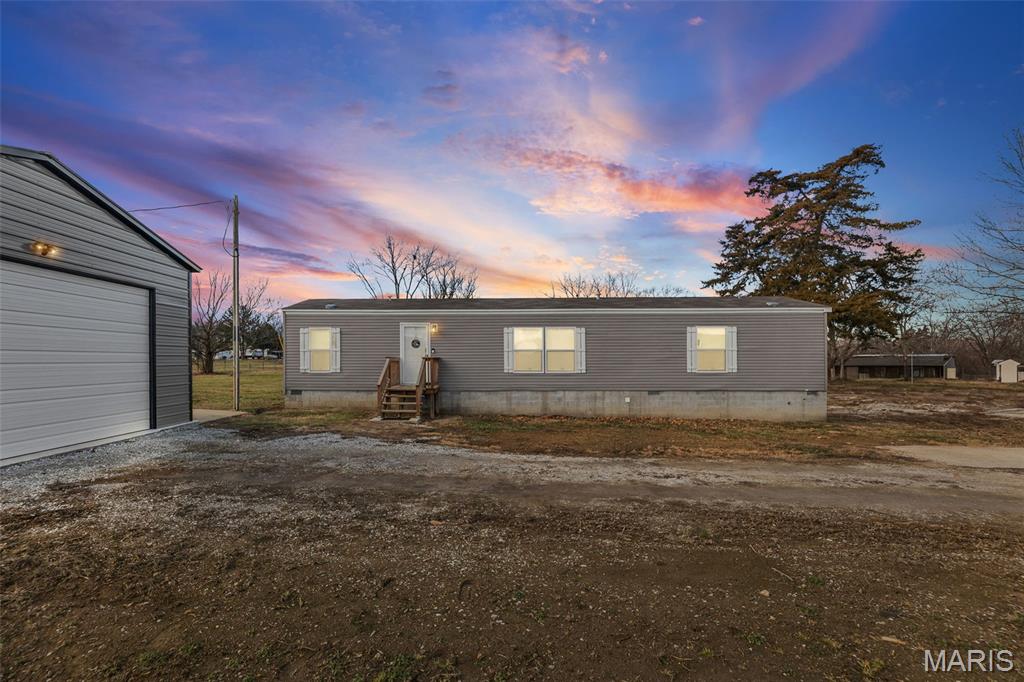Welcome home to this gem!  Ideally located just minutes from Carlyle Lake and only one mile from Keyesport Marina. Situated on nearly an acre, this two-bedroom, two-bathroom home offers the perfect blend of country charm and recreational convenience. Inside, you'll find an inviting open floor plan with custom built-ins. Perfect sized living room with new laminate flooring. The kitchen features a large island perfect for entertaining and can also be used as a dining space, custom cabinetry, farm house sink and new laminate flooring. There are 2 bedrooms and 2 bathrooms. The oversized primary bedroom offers a walk in closet and a beautiful primary bathroom with sliding barn doors, custom cabinets and  walk in tile shower. Outdoors, the property truly shines with a newly built detached 25x25 pole barn with electric ideal for boat storage, hobbies, parking, or extra equipment. The expansive lot provides room to enjoy peaceful surroundings while remaining close to the lake, marina, and outdoor activities. Whether you're seeking a permanent home or a vacation retreat near the water, this ideal location offers endless possibilities. Video and audio surveillance.
