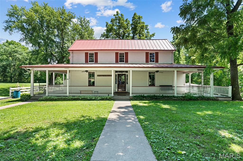 PERFECT AS A WEEK-END GETAWAY, VACATION HOME OR A FULL-TIME RESIDENCE! This spacious country farmhouse, originally built in or around 1900 or before and expanded over the years, sits on approximately 4.25 +/- beautiful acres and offers the perfect blend on the historic charm and modern convenience. The property features a large pole barn with concrete floors, electricity, a loft, and a lean-too, along with a utility shed, charming playhouse, tree house deck and swing set,  A welcoming wraparound covered front porch adjoined with deck and durable red metal roof adds to the home's classic country appeal. Inside you will find the original staircase at the front entry, a comfortable living room and a cozy primary suite with full bath. The oversize kitchen offers abundant of space for hosting family gatherings and guest, complete with breakfast bar, stylish backsplash, lots of cabinetry and shelves for storage. Sizable breakfast area. A separate dining room with original post & beam exposed and access to the deck. The main level also includes a convenient laundry room, full bath, closet space and multiple exterior doors for easy access to the outdoors. Upstairs, you will find 3 generous sized bedrooms, possible 4 and bonus room that can serve as a sitting room or office etc. and full bath with claw tub.  The lower level features a walk-out partial stone cellar and concrete basement for storage and utility space. Outside, enjoy the peaceful country setting with a circular driveway, expansive yard, and plenty of open space to relax, garden or entertain. Newer updates in UL Quaker windows in 2018, Carpet 2020, HVAC 2020, and 2 mini splits 2026. Don't wait-call to make your appt. today.