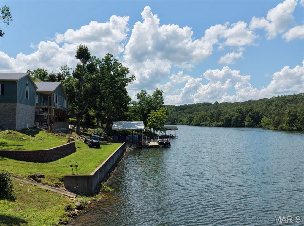 ONE OF THE BEST lakefront 4 bedroom 3 bath home in DEER RUN on the market with breathtaking views throughout and in the CENTER OF THE WIDEST PART OF THE LAKE! This spacious home features custom cabinetry, all natural stone countertops throughout home, Anderson windows and sliders, a beautiful brick fireplace, and expansive windows that bring the lake views inside. AMAZING outdoor living with both a covered deck with stamped stone concrete and open Trek composite deck overlooking the water and private dock. The large finished basement offers a COMPLETE SECOND LIVING QUATERS with a full kitchen, plenty of storage, additional bedroom and bath, and bar area perfect for entertaining and easy access to the lake. Complete with a large dock, this property is ideal for relaxing, hosting guests, and enjoying lake life at its best.