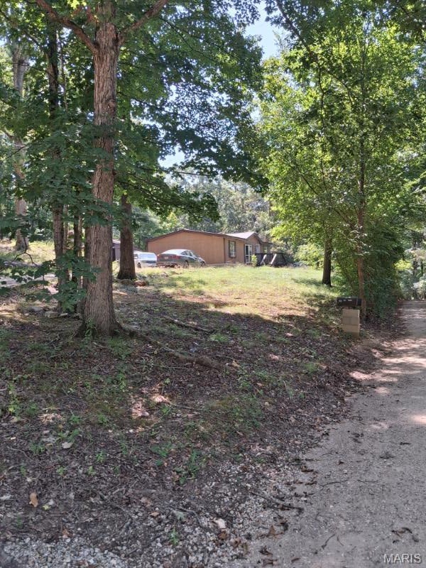 This serene (10 lot parcel) -1.38 acres offers a 1994 manufactured home, with 3 bedrooms, 2 bathrooms. The home is need of TLC but it is solid with new vinyl flooring recently installed! Most supplies to finish the addition and renovations are present and convey with the sale! The sliding door, where a patio was planned, is a new, energy star vinyl door! The storage shed and workshop has electricity and ample storage for your 4 wheeler, side by side and lawn mowers with plenty of room to spare for the yard tools and tool boxes! Although the parcel sits on a hillside, there are 2 flat surfaces where older buildings were removed, that would be great for bringing in additional mobile homes to maximize the rental income potential of this parcel. There are 2 electricity meters/poles on the property. With over $40,000 invested in the addition and the remaining supplies to finish the remodel, this parcel is priced to move at $119,900. Motivated sellers! Bring Reasonable offers! Call Now!