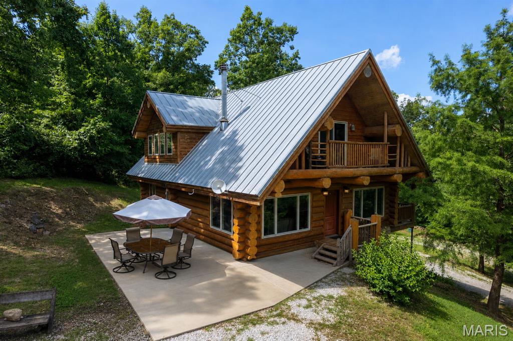 Looking for a one-of-a-kind log home with breathtaking lake views? Look no further! Custom built by Katy Trails Log & Timber Frame Homes, this stunning home overlooks the beautiful Lake Kah-Tan-Da Community, where you'll enjoy access to three private lakes and peaceful surroundings.

Step inside and immediately appreciate the soaring wood-lined ceilings, rustic craftsmanship, and a custom wood-burning fireplace that serves as the heart of the living room while providing exceptional heating efficiency. The open-concept floor plan is perfect for entertaining and offers seamless access to the covered porch, where you can relax and take in the picturesque lake views.

The spacious main-level primary suite features a private en-suite bathroom, and main-level laundry adds convenience to everyday living. Upstairs, you'll find a generous loft overlooking the great room, filled with natural light from expansive windows, along with a private balcony and two additional bedrooms.

The walk-out basement offers abundant storage and endless possibilities for future living space. Some renovations have already been completed using beautiful reclaimed barn wood, adding even more warmth and character to this unique home. The heated and cooled John Deere garage provides the perfect space for a workshop, lawn equipment, or additional storage.

Whether you're looking for a full-time residence or a peaceful lakeside retreat, this extraordinary log home offers timeless craftsmanship, stunning views, and a lifestyle that's hard to find. Schedule your private showing today!