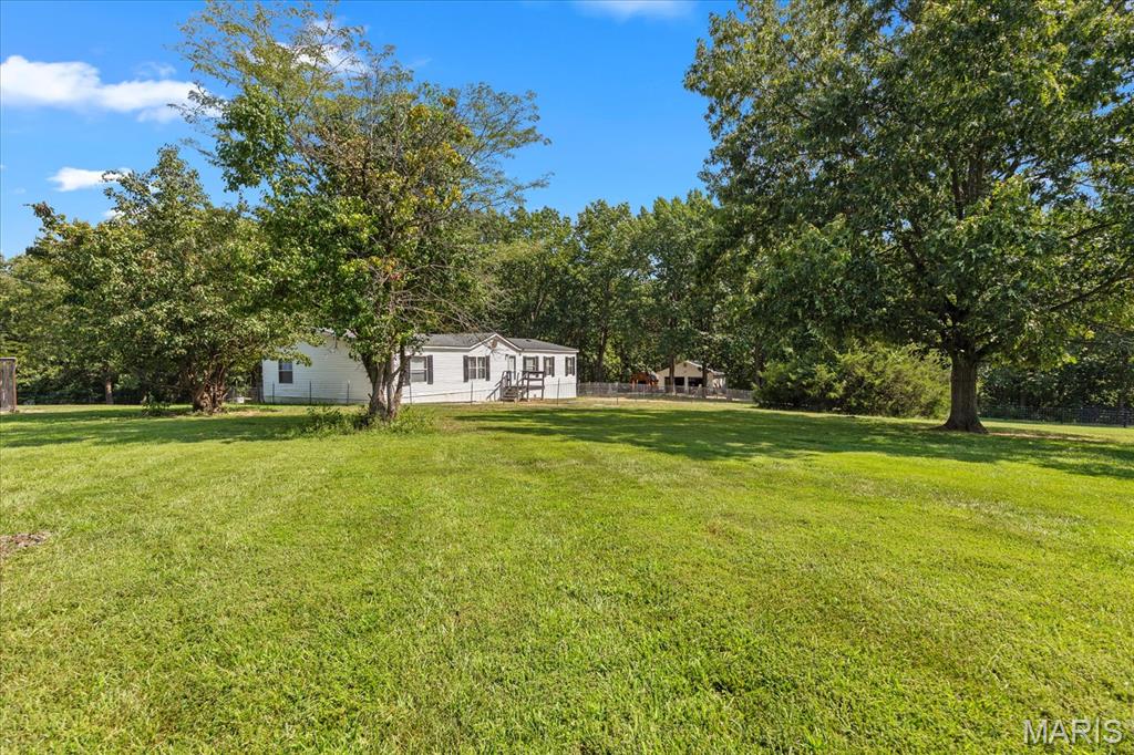 Welcome to this beautifully maintained and thoughtfully updated home, offering the perfect combination of comfortable living, modern updates, and country functionality. This popular 3-bedroom split-bedroom floor plan offers a spacious and functional layout, featuring a formal dining room, large kitchen with a walk-in pantry, breakfast bar, and center island. All kitchen appliances stay, making this home truly move-in ready. Recent updates throughout the home elevate the overall look and feel, including new flooring and fresh paint throughout, an updated kitchen, and a beautifully renovated primary bathroom. The result is a fresh, inviting interior with modern touches and a warm, comfortable feel. Step outside and enjoy the best of country living. New roof on the house and garage!!  The 20x10 covered deck has been freshly stained, creating the perfect spot to relax, entertain, or enjoy your morning coffee while taking in the peaceful surroundings. The pastures are fenced with wire cattle fencing, making this property well suited for livestock, donkeys, or other agricultural pursuits. A small livestock lean-to provides convenient shelter for your animals. Adding even more value and versatility, approximately 3 acres of the property are wooded, offering privacy, natural beauty, and the potential for selective logging or timber use. The property also features an impressive 27x25 detached heated garage on concrete. This versatile building includes a garage door opener, elecrtic furnace, and its own separate meter, making it ideal for vehicles, equipment, hobbies, a workshop, or additional storage. As an add bonus there is a chicken coop that stays on the property. With its extensive updates, spacious floor plan, fenced pastures, wooded acreage, livestock accommodations, and heated detached garage, this property offers a wonderful opportunity to enjoy comfortable, move-in-ready country living with room to farm, explore, and make the property your own. This is the kind of property that offers both the comforts of home and the flexibility of country living — don't miss your opportunity to see all it has to offer!