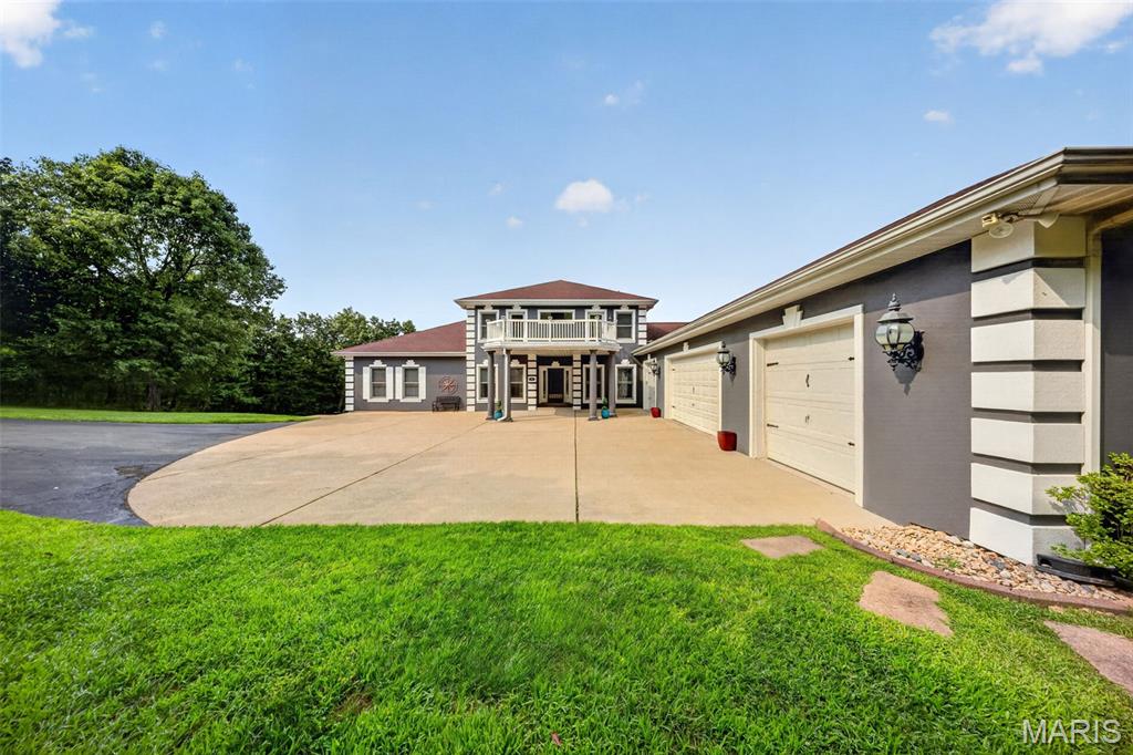 Nestled in the scenic, rolling hills of Wildwood, Missouri, this stunning estate offers the perfect blend of sophisticated design, high-end modern upgrades, and a private backyard oasis all while being just minutes from shopping, restaurants, and I-44. From the moment you arrive, the pride of ownership shines through, highlighted by a freshly painted exterior completed just two years ago.

Step inside to an entrance foyer, beautifully bookended by a formal dining room and an elegant sitting room. The main level flows effortlessly into a spacious living room featuring updated, durable luxury vinyl plank flooring that seamlessly combines style with low-maintenance living. Culinary enthusiasts will fall in love with the expansive kitchen, which offers abundant storage in custom cabinetry, a generous walk-in pantry, and a large central island perfect for meal prep and casual gathering. Nearby, the family room serves as the ultimate media hub, hosting a custom entertainment system with a television, soundbar, receiver, and sound system fully wired to deliver seamless audio throughout the main floor and straight out to the outdoor living spaces. Tucked away on this main level for ultimate convenience is the primary suite—a spacious, private sanctuary boasting two walk-in closets and a luxurious en suite bathroom.

The outdoor amenities are designed to embrace Wildwood’s beautiful natural backdrop and provide a true resort-style experience. Off the main level, a screened-in porch offers a peaceful retreat to unwind while taking in a truly breathtaking, show-stopping view of the property. Take the newly replaced deck stairs down to the spacious, securely fenced in backyard. A sparkling, recently tiled in-ground saltwater swimming pool also awaits outside, complete with a brand-new safety cover for ultimate peace of mind.

Upstairs, the home continues to impress with accommodations designed to give everyone their own private retreat, highlighted by the fact that every single bedroom features its own private balcony with elevated views of the property. Two of the upper-level bedrooms share a convenient Jack-and-Jill bathroom, while the third upstairs bedroom enjoys easy access to another beautifully appointed full bathroom.

The incredible living space continues in the fully finished walk-out basement, which doubles as an entertainment haven and guest quarters. Here, you will find a dedicated theater room for movie nights, a recreation space, a half bath, and two large, individual storage rooms to keep the home perfectly organized. A fifth bedroom and another full bathroom provide the perfect setup for guests, with a walk-out door leading directly to the backyard. To complete this exceptional property, the entire home is served by a premium Pura UV water filtration system and heavy-duty security doors have been installed at both the front and rear entrances for added peace of mind. Experience the pinnacle of eco-conscious luxury with a state-of-the-art, three-zoned geothermal heat pump system, an ultra-efficient technology that harnesses the earth’s constant underground temperature to provide whisper-quiet, customized climate control across three distinct areas of the home. Perfect for auto enthusiasts or those needing extra storage, the expansive four-car garage offers abundant, secure space for a multi-vehicle collection, a dedicated workshop, or recreational gear. The garage also includes a beautifully integrated, high-speed EV charging station. With a convenient location near Rockwood schools, this feature-packed Wildwood masterpiece is truly a rare find.