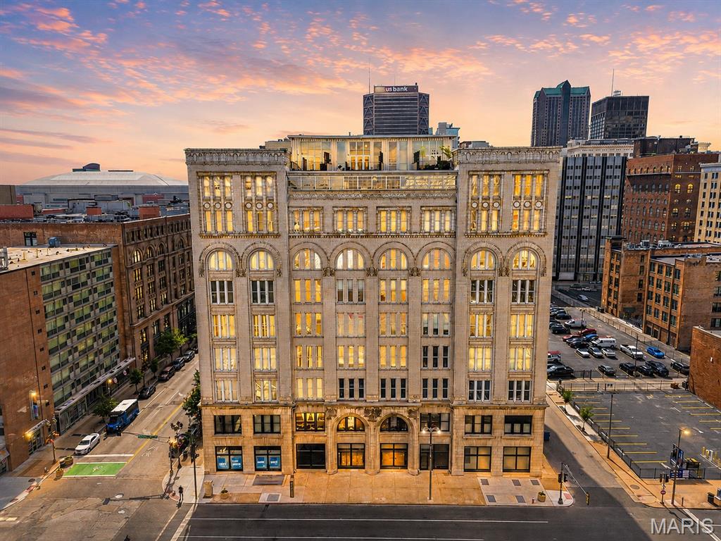 Experience elevated downtown living in this stunning 2-story penthouse loft located in the highly sought-after Meridian building in the heart of St. Louis’ vibrant Loft District. Offering over 2,200 sq ft of designer-inspired living space, this rare 2-bed, 2-bath residence seamlessly blends historic character with upscale modern finishes. Soaring 14-foot ceilings, expansive windows, exposed architectural elements, and rich hardwood flooring create a dramatic yet inviting atmosphere filled with natural light. The open-concept main level features a beautifully appointed kitchen with custom cabinetry, granite countertops, upscale stainless steel appliances, built-ins, and an oversized breakfast bar perfect for entertaining. A striking 2-story staircase leads to an additional entertainment space complete with a wet bar, fireplace, and access to your own private rooftop terrace showcasing breathtaking skyline views. The luxurious primary suite offers a true retreat with custom closets, a spa-like bath featuring a jetted tub and separate shower, and generous space throughout. Additional highlights include in-unit laundry, assigned storage, and TWO tandem garage parking spaces. Perfectly positioned near downtown dining, nightlife, sporting events, and entertainment, this one-of-a-kind penthouse delivers the ultimate urban luxury lifestyle.