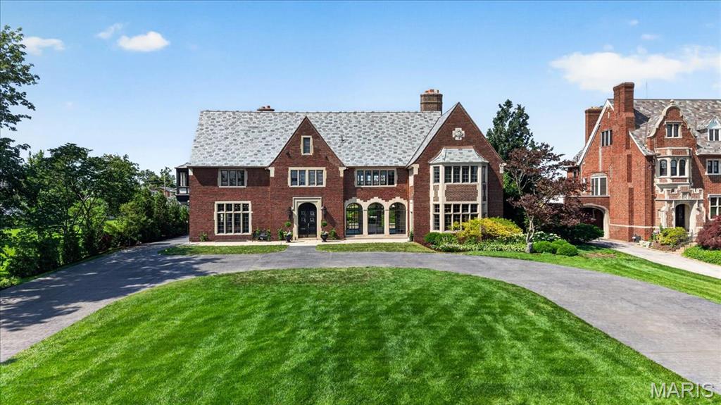 A rare and storied 1926 Tudor Revival by renowned architects Maritz & Young, originally commissioned for Louis Monheimer, Vice President of the May Company. Set on historically significant grounds from the 1904 World’s Fair Japanese Garden Exhibit, this estate blends architectural legacy with masterful modern design.  A grand foyer welcomes with original terrazzo flooring, deep closets, and a sweeping circular staircase beneath the dramatic John-Richards “Japanese Cascading Wisteria” Shiro Noda chandelier.  The fully reimagined kitchen is a showpiece of design and performance, featuring custom terrazzo flooring, bespoke cabinetry, and elite appliances including a Sub-Zero 48” refrigerator, ILVE Italian Majestic range, and multiple Wolf ovens. Finished with Anne Sacks marble, dual dishwashers, wine storage, integrated Art TV, and custom banquette seating.  Timeless craftsmanship defines the living spaces with a restored original fireplace, plaster walls, waxed ceilings, and leaded glass windows with power shades. Fine art lighting and illuminated built-ins enhance the ambiance.  A heated slate loggia with signature triple arches seamlessly connects indoor and outdoor living.  The primary suite offers a private retreat with gas fireplace, terrazzo floors, and motorized shades. A couture dressing room with Carrara marble island leads to a spa bath with steam shower, Anne Sacks tile, heated floors, and integrated styling station.  The Gardens — A Living Work of Art.  The grounds are extraordinary, curated with Japanese influence by renowned horticulturist Ben Chu of the Missouri Botanical Garden. Sculptural maples, tiered landscaping, and a black granite veranda create a serene, immersive setting. Authentic 18th-century lanterns and illuminated pathways transform the landscape at dusk.  The resort-style pool features new Gunite construction, limestone coping, and dramatic “Magic Bowl” water features. A Japanese Pagoda-inspired bathhouse includes a full kitchen, full bathroom and chic family room with bespoke bamboo ceiling.  Notable Brand New Enhancements - New slate roof (Glandt Roofing), New copper gutters, Upgraded attic insulation, Relined and restored original fireplace, New leaded glass windows (select rooms), Custom California Closets throughout, New security system with cameras, New electric gate, Whole-house water softener & purification system, Commercial-grade internet, Integrated surround sound across gardens, pool, and interior spaces, Extensive new landscaping.  A once-in-a-generation offering—where historic provenance, world-class design, and resort-level living converge in one of St. Louis’ most significant estates.