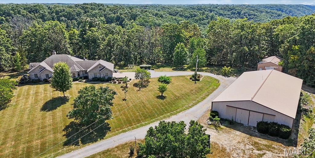 One of a Kind 1 Owner Custom 80 acre Estate In Warrenton with Indoor Inground Pool and 2 Outbuildings. Pulling into this Estate, you will feel like you are a Ewing on a Dallas afternoon (look it up if you dont know the reference) as the long driveway opens up to your stunning custom parcel. You will first notice 2 outbuildings, one of which is nearly 6000 Sq Pole Barn with Paint and Sand Blasting Box, Office, and Bathroom. The other building is about 2000 Sq ft. The House is truly a custom masterpiece with 4 Bedrooms 4  full baths and 2 kitchens. Entering the home a stunning vaulted Great Room wall of windows and  Fireplace. There is a spacious dining room off the great room that leads to your massive custom kitchen with custom cabinetry and countertops for days. Your breakfast room leads to your custom rotunda like sunroom that wraps around the back of your residence. The primary suite offers a custom oversized walk in closet and sep tub and shower. There are 2 additional bedrooms on the main level, one that is currently being used as a sitting room and library. Completing the main floor are 2 additional full baths, one is directly off the garage perfect for after a full day of working in the shop and a large main floor laundry/ Mud room. Your lower level is a true extension of your residence, first find your stunning indoor Fiberglass pool and Hot tub area! You will also find a 4th bedroom and 4th full bath. There is a full kitchen, dining room, office and safe room as well. This parcel as mentioned sits on nearly 80 acres, has a new septic system,  and geothermal heating and air system!