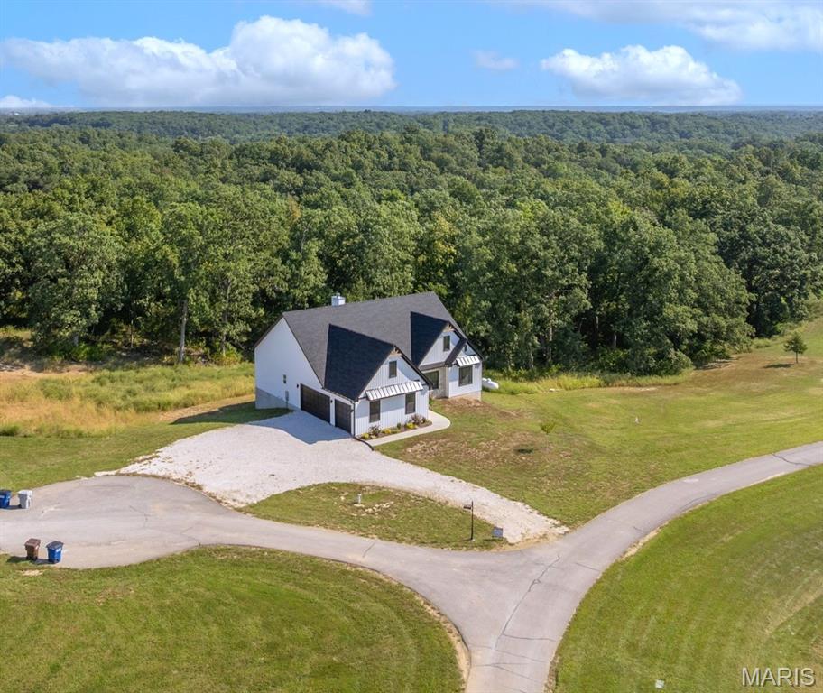 The search is over! A home of truly remarkable craftsmanship that checks every box sitting on 5+/- acres in Silex, Mo! This brand new home boasts 1950 sq ft of living space with 3 sizeable bedrooms and 2 full bathrooms. Enter through the 8ft nearly full glass door into your open main living space with 11 ft ceilings. Living room features a stone wood burning fireplace adjoined by recessed built in shelving, coffered ceiling with box beam inlay and a wall lined with over-sized windows accompanied by transom windows that let in so much natural light you'll never need to touch the light switch. The kitchen is magazine-cover worthy with full quartz counter tops, huge center island with farmhouse sink and enough cabinet space that the only thing you'll need to keep in the 8x5 pantry is food! Master bedroom is large enough to be considered its own apartment and has a 9x7 walk-in closet and ensuite bathroom with cave shower, double bowl vanity and linen closet. Walk-out basement is ready to be finished off however you could imagine and has extra water lines ran to easily put a wet bar and make it the perfect entertainment space. Have a project that needs finished up? Pull it in to the oversize 3 car garage measuring 30 ft wide and 25 ft deep with 8 ft tall doors and TWO 220 volt outlets and if you manage to fill that up, don't worry because there is a great spot on the property to build a detached garage/shop! Other features include 93% efficiency propane furnace with built in whole home humidifier and 14x14 back deck with disconnect for mini split if you ever wanted to enclose it and make it a 3 season room.