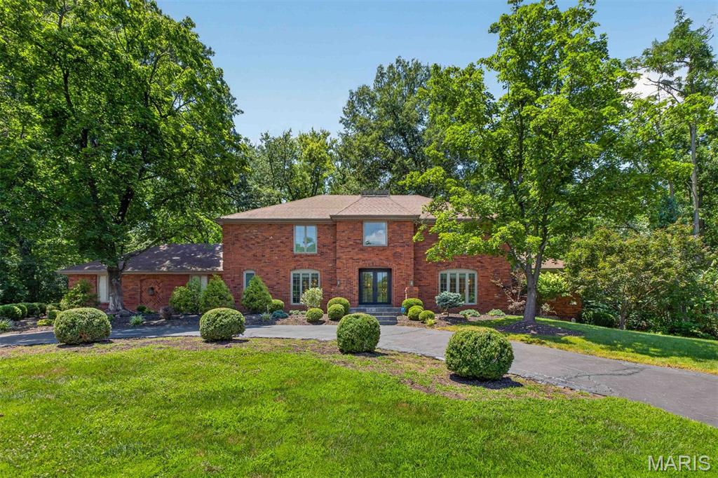 Gracefully nestled on more than 1.5 private acres, this timeless brick classic was thoughtfully reimagined in 2021, offering exceptional design, and an atmosphere of quiet elegance and retreat. 

A dramatic two-story reception hall with a sweeping staircase unites formal and casual living spaces, designed for elevated entertaining and everyday comfort. At the heart of the home, the vaulted great room showcases soaring timber-beamed ceilings, a handsome fireplace, wet bar, and French doors that open to a series of tranquil courtyards. The beautifully updated kitchen boasts Sub-Zero and Viking appliances, quartz countertops, a breakfast room, and opens to a laundry/mud room, attached garage, and an expansive patio. The main-level primary suite features a custom walk-in dressing room and a luxury new bath with dual vanities, a jetted soaking tub, and separate shower. 

Upstairs, four generously sized bedrooms are complemented by two beautifully appointed bathrooms. The expansive lower level presents excellent potential for recreation, wellness, or additional living space tailored to your lifestyle. 

Surrounded by mature trees, the grounds provide a wonderful retreat and leisurely walks to the neighborhood lake continue the peaceful connection to nature. Conveniently located near premier schools, hospitals, shopping, dining, and everyday conveniences, this is a rare offering that seamlessly blends timeless architecture with modern luxury and private seclusion.