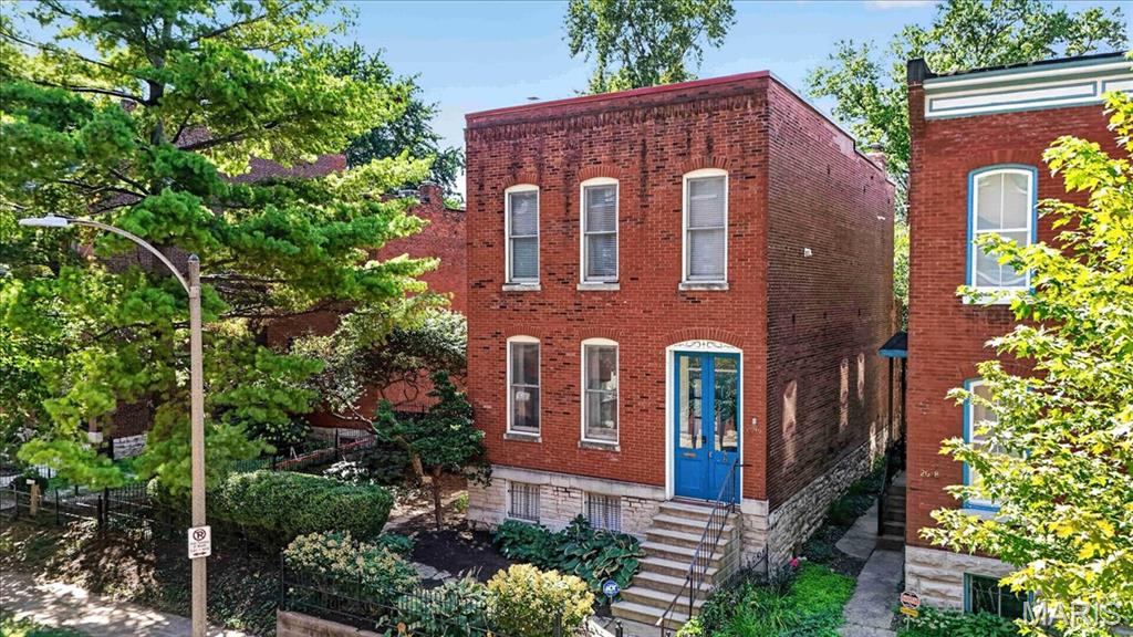 Historic character, generous living space and an unusually large lot come together at 2016 Hickory in the heart of Lafayette Square. With nearly 2,000 square feet above grade, this three-bedroom home features tall ceilings, hardwood floors, exposed brick and beautiful original fireplaces that give the interior a distinctive sense of place. The main level offers spacious living and dining rooms along with an updated kitchen featuring granite countertops, stainless appliances, a commercial-style range and abundant cabinetry.

All three bedrooms are upstairs, including a large master bedroom with tall windows and hardwood floors. A full bath and convenient second-floor laundry complete this level.

Downstairs, the finished lower level is one of the home's best surprises. Exposed limestone walls create an atmosphere tailor-made for a speakeasy-style bar, media room or late-night gathering spot, with approximately 500 additional square feet of finished space and a convenient half bath.
Outside is where 2016 Hickory really separates itself. The rare double lot creates a remarkably large, private backyard with plenty of room for entertaining, gardening, pets or simply enjoying some green space in the city. Covered two-car off-street parking with an overhead garage door is another major bonus. All of this is just blocks from Lafayette Park and the restaurants, coffee shops and neighborhood favorites that make Lafayette Square one of St. Louis' most distinctive places to live. Historic city living with the yard, space and parking that are so hard to find.