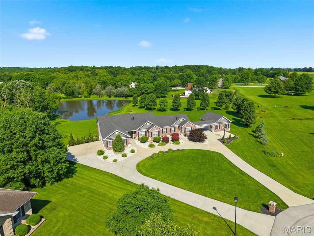 Stunning 6 bed, 5 bath brick ranch in St. Paul on 3 acres with privately owned lake! This spacious home offers an Open floor plan with a warm and inviting great room featuring a fireplace. Kitchen features custom white cabinetry, granite countertops. Formal dining overlooks lake. Breakfast area with French doors to deck with lake views. Primary suite with coffered ceiling, full bath, separate tub/shower, walk-in closet. A fully equipped in-law suite provides incredible flexibility, complete with its own kitchen, living area, private bedroom suite, full bath, and private deck, plus separate access to a breezeway and 2-car side-entry garage. The finished lower level expands your living space with two additional bedrooms, full baths, a rec room, sitting area, and bonus room. Additional features include a 3-car side-entry garage on the opposite end of the home, circular driveway, cul-de-sac location,  extensive professional landscaping, along with invisible fence in both front and back yard.