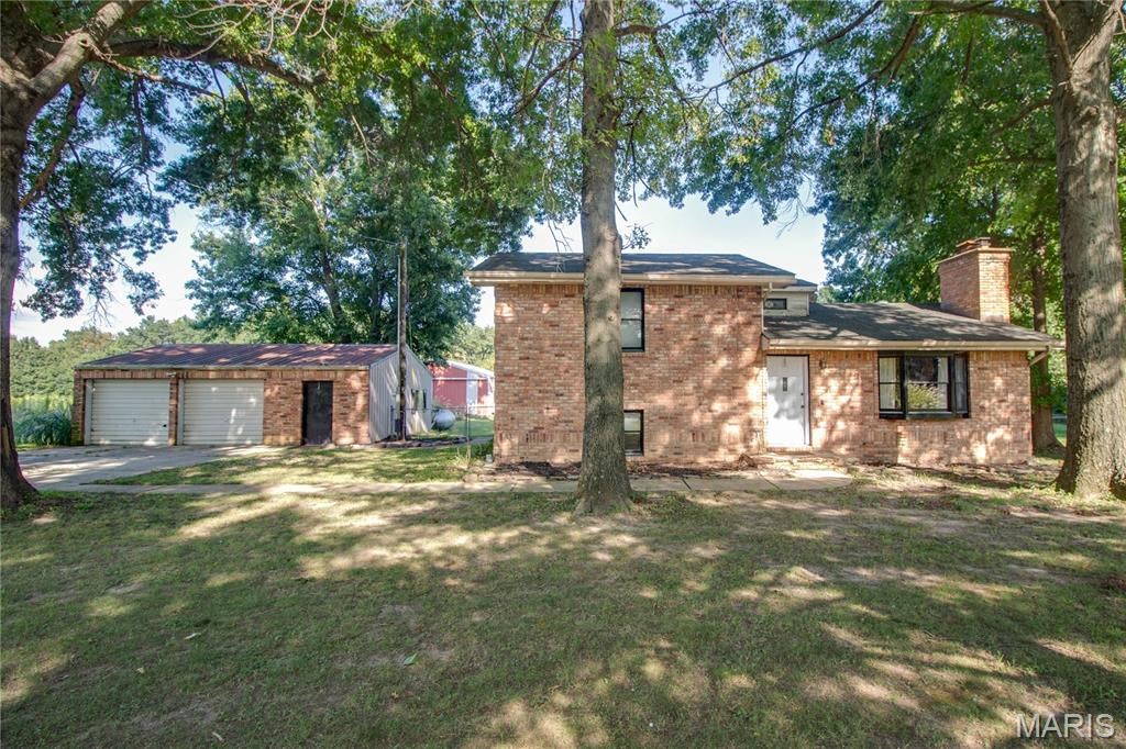 This beautiful updated 3-bedroom, 2-bath home offers the perfect blend of comfort, character, and country living on approximately 2 acres. The main level features an open kitchen and dining area, a spacious living room with a stone fireplace, and a relaxing sunroom overlooking the property. The generous primary suite includes a large sitting area, walk in closet and a beautiful private bathroom. Downstairs, a finished bonus room provides additional space for a family room, home office, hobby area, or recreation room. Step outside to enjoy the large deck, ideal for entertaining or relaxing while taking in the peaceful surroundings. The property also features an oversized detached two-car garage and a large barn with two stalls, making it an excellent opportunity for those looking for space for hobbies, animals, or additional storage. Recent updates include new kitchen cabinets. counters, appliances, new flooring throughout, lighting and some plumbing.  Conveniently located between Godfrey and Jerseyville, this property offers a wonderful opportunity to enjoy a rural lifestyle while remaining close to area amenities.
