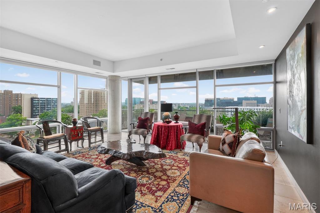 High above the Central West End, this sophisticated 9th-floor corner residence offers a rare and cinematic way to live - wrapped in sky, treetops, city lights, sunrise, sunset, and sweeping unobstructed views to the East, South, and West. From the Great Room, primary suite, or expansive private balcony, the world feels open, luminous, and entirely your own. A secure elevator opens directly into a private foyer, setting the tone for a residence that feels exclusive, intimate, and quietly glamorous. Inside, 10’ ceilings, Spanish limestone and marble floors, marble countertops, designer lighting, and a sleek European-style kitchen create a seductive backdrop for elegant nights in, effortless entertaining, and everyday indulgence. This two-bedroom, two-and-a-half bath condo with a den has been beautifully enhanced with a Sub-Zero refrigerator, custom cabinet installation, a Wolf cooktop and hood, an added ice maker, automatic living room and primary bedroom shades, new balcony lighting, and custom closet systems. The lifestyle is seamless and elevated, featuring two assigned garage parking spaces directly next to the elevator, a storage unit, a door person, a fitness room, a guest suite, and a party/conference room with a wet bar and kitchen. Step outside and the best of the Central West End is at your feet—beloved cafés, acclaimed restaurants, galleries, boutiques, Forest Park, BJC/WashU Medical Campus, and the vibrant pulse of one of St. Louis’ most iconic neighborhoods. A sultry, sky-lit sanctuary for those who want beauty, privacy, convenience, and the city shimmering just beyond the concrete and glass.
