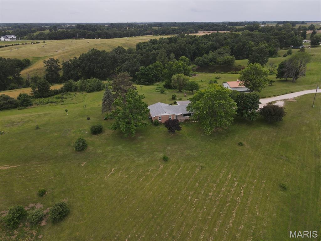 You don't find these views every day!  Sweeping 360-degree countryside views in every direction from this very well-kept brick ranch just west of Ewing - located along blacktop Hwy 156 this is an ideal location just outside of town that offers all the benefits of country living.  Enjoy the wildlife - quail, turkey, deer, bald eagles - you'll see it all, fish from the pond, have a full garden, harvest the mature fruit trees and enjoy the view from the back deck or patio.  There is so much outdoor space to enjoy.  Inside, you'll find an easy floor plan, open kitchen (all appliances convey!), oversized living room and three full bedrooms on the main floor.  You'll appreciate the large bathroom with new counter & vanity table.  The full basement offers plenty of storage and could easily be finished out for more living space or bedrooms, with a full bathroom downstairs that has just been updated.  The basement walks out to the secluded backyard where the perennials are in full bloom!  The back deck and covered patio are the ideal spots for morning coffee or evening barbecues.  Take advantage of the 2-car garage with a covered patio leading to the home, and the new (2019) 30x40 metal utility building offers parking for an additional 4 vehicles and plenty of storage/workshop space.  Conveniently located on blacktop Hwy 156, this is a short drive to Lewis County Schools, 20 min to Quincy, IL or 40 min to Kirksville, MO.  

New HVAC (heat pump & central air) installed in 2018, new shingle roof in 2026, new septic tank in 2025, new windows in 2017, brick has been tuckpointed, basement walls anchored (2025), and this home was built by an electrician - so there are plenty of lights & outlets.  All you have to do is move in and enjoy!

Utility providers here include REC Electric, Lewis County Water, Brightspeed Internet and the ADT & FICO security systems can convey.