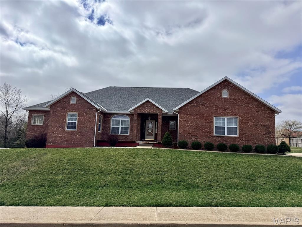 Built for space, comfort, and lasting construction, this solid brick home offers approximately 4,900 square feet of thoughtfully designed living space with classic architectural details throughout. Features such as crown molding, tray ceilings, solid wood doors, and chandeliers add character without sacrificing functionality. Upon entry, a tiled foyer welcomes you into the home’s spacious layout. The main floor includes a spacious primary suite with an en suite bathroom featuring a dual vanity, jetted tub, and separate stand up shower. Two additional bedrooms are also located upstairs with a shared hallway bathroom, along with a comfortable living room and a dedicated office with solid wood built in bookshelves. The spacious kitchen features a center island, gas stove, and trash compactor, and provides access to the covered rear deck. A conveniently located laundry room comes complete with washer and dryer. The carpeted staircase leads to an expansive walk out basement offering generous additional living space, including a large family room, a recreational area ideal for entertaining or hobbies, an additional bedroom, and a full bathroom. Lower level access includes concrete patio with sidewalk up to front door for maximum efficiency of use! Exterior amenities include an in-ground sprinkler system, level front and back yard, sidewalks throughout the subdivision, and a new roof installed in 2025. Conveniently located near Freedom Elementary and the main gate of Fort Leonard Wood, this home offers size, layout, and location rarely found together.