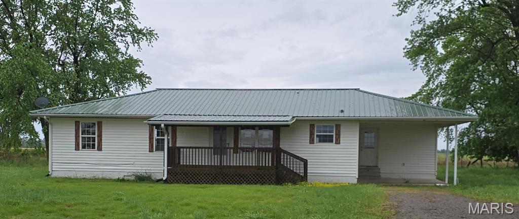 Enjoy peaceful country living just outside of town in this 3 bedroom, 2 bath home situated on 5.95 acres with wide-open views and beautiful sunsets. Offering 1,428 sq ft of living space, this home features an open-concept layout with spacious living and dining areas, a functional kitchen with ample cabinet storage, and a split-bedroom design. The primary suite includes a private bath, while two additional bedrooms offer flexibility for family, guests, or a home office. Step outside to a covered front porch overlooking open farmland—perfect for relaxing evenings and morning coffee. The property includes room for animals, gardening, and future outbuildings, with existing rural structures adding to the country charm and usable storage. Property will need electrical updates and installation of a water heater, making this an excellent opportunity for buyers looking to build equity and customize.