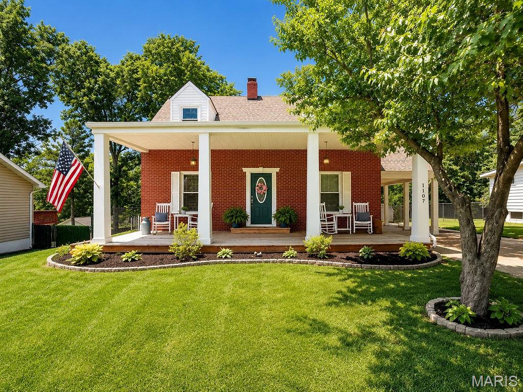 Welcome home to this beautifully updated 2-story brick charmer offering timeless character, modern updates, and incredible curb appeal! Nestled on a spacious, level lot, this 3-bedroom, 2.5-bath home features over 2,100 sq. ft. of living space with gorgeous hardwood floors, detailed woodwork, and an inviting floor plan. The large living room showcases a stunning fireplace and flows seamlessly into the formal dining room, perfect for entertaining. The updated kitchen offers custom cabinetry, stainless steel appliances, ample counter space, and abundant natural light. Upstairs, you'll find generously sized bedrooms, including a spacious primary suite retreat with a cinderalla tub from the 1950s and original to the house. The partially finished walk-out lower level provides additional living space with a second fireplace, family room, full bath, and plenty of storage options. Recent updates and stylish finishes throughout create a move-in-ready home you'll love.  Step outside and enjoy the expansive covered front porch, rear covered deck, and fully fenced backyard—ideal for relaxing, entertaining, pets, or play. The oversized detached garage/workshop, carport, and extended driveway provide exceptional parking and storage opportunities. Conveniently located near schools, parks, shopping, dining, and commuter routes, this home combines small-town charm with everyday convenience. If you've been searching for character, space, and outdoor living all in one package, this is the one!