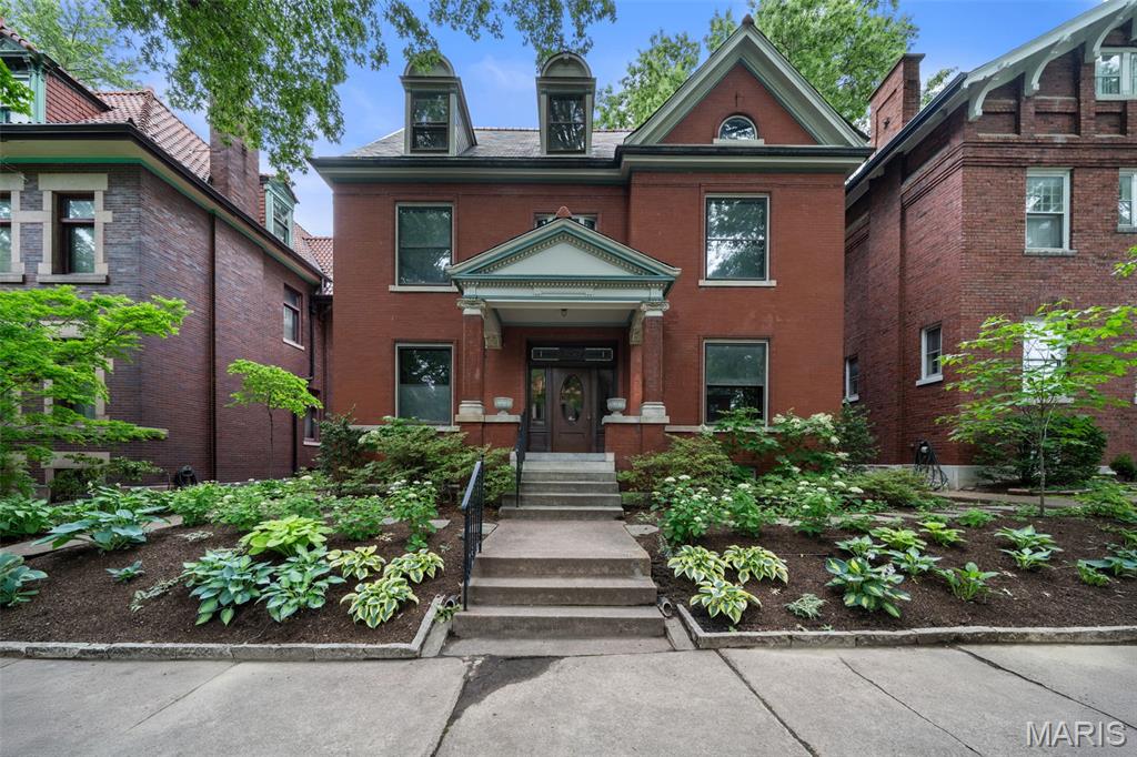 Welcome to 3537 Crittenden, a beautifully preserved and thoughtfully renovated home on one of Tower Grove East’s most coveted blocks, just steps from Tower Grove Park and surrounded by a community of wonderful neighbors. The partially gated, one-way street creates a slower-paced neighborhood atmosphere ideal for outdoor gatherings, while still being within walking distance of vibrant restaurants, shops, Tower Grove Farmers' Market, and many year-round area events. Built in 1901 and lovingly maintained by just a handful of owners, the home seamlessly blends historic character with modern luxury. Over the past year, the property has undergone an extensive renovation focused on preserving architectural details while modernizing systems. The expanded kitchen features a dramatic 10-foot island, ceiling-height cabinetry, a custom hood, premium appliances, and the original butler’s pantry with beadboard accents. Large windows overlook the manicured lawn and gardens, while a pass-through window to the deck creates effortless indoor-outdoor entertaining. The grand foyer showcases a sweeping staircase, soaring ceilings, and exceptional original millwork. Formal living and dining rooms each feature original fireplaces, while functioning pocket doors throughout the main floor provide both character and flexibility between rooms. Two additional living spaces offer flexibility for a den, office, guest room, or playroom, and a designer powder room completes the main floor. Upstairs, the expansive primary suite spans over 1,000 square feet and includes a spa-inspired bath with a soaking tub, custom tile shower, double vanity, along with a walk-in closet and adjacent laundry area. Two additional bedrooms, an updated guest bath with original marble slab walls, and a screened patio overlooking the backyard complete the second floor. The third floor offers a fourth bedroom and over 800 square feet of incredible entertainment space with treetop views. The beautifully landscaped grounds feature mature plants, seasonal flowers, a water garden, and a stone patio — creating a private, low-maintenance backyard oasis with drip and sprinkler systems. Additional updates include new plumbing, electrical, lighting, refinished hardwood floors, new carpet, and EV charging capabilities in the two-car garage.