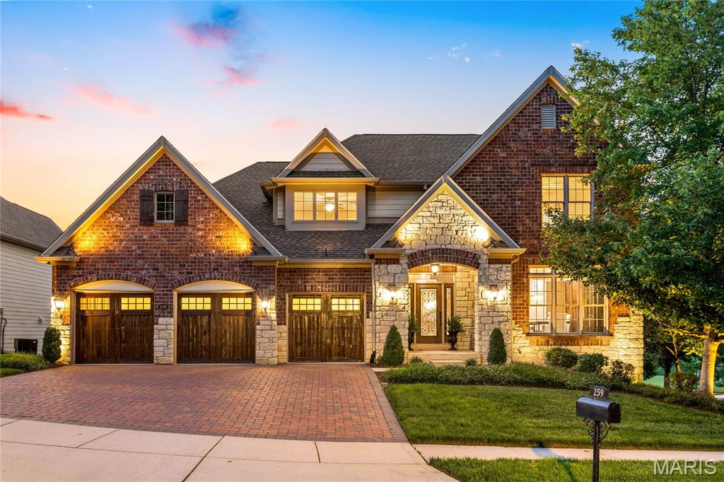 This distinguished freestanding 1.5-story villa from Simon Homes exemplifies architectural refinement and thoughtfully curated finishes throughout. Enhanced by newly installed designer lighting and wide-plank hardwood flooring extending throughout the main level, the home offers a sophisticated blend of timeless elegance and modern style. A gracious foyer leads to the formal dining room, enhanced by an elegant tray ceiling and refined proportions. The great room commands attention with its marble fireplace, framed by custom built-in bookcases, offering a stately focal point within the main living space. The chef’s kitchen is appointed with 42-inch custom cabinetry, premium quartz surfaces, and an expansive 7-foot peninsula designed for both culinary precision and seamless entertaining. The adjoining breakfast room transitions effortlessly to a sunroom via an atrium door, extending the living space with natural light and architectural continuity. The main-level primary suite is meticulously designed as a private retreat, featuring two generously sized closets and a spa-caliber bath appointed with an upgraded shower system and luxury finishes. The upper level provides two additional ensuite bedrooms, each offering privacy and well-appointed baths. The finished lower level enhances the home’s versatility with a spacious recreation room, fully equipped wet bar, private guest suite, and half bath. Together, these exceptional spaces create an ideal setting for both comfortable everyday living and gracious entertaining.