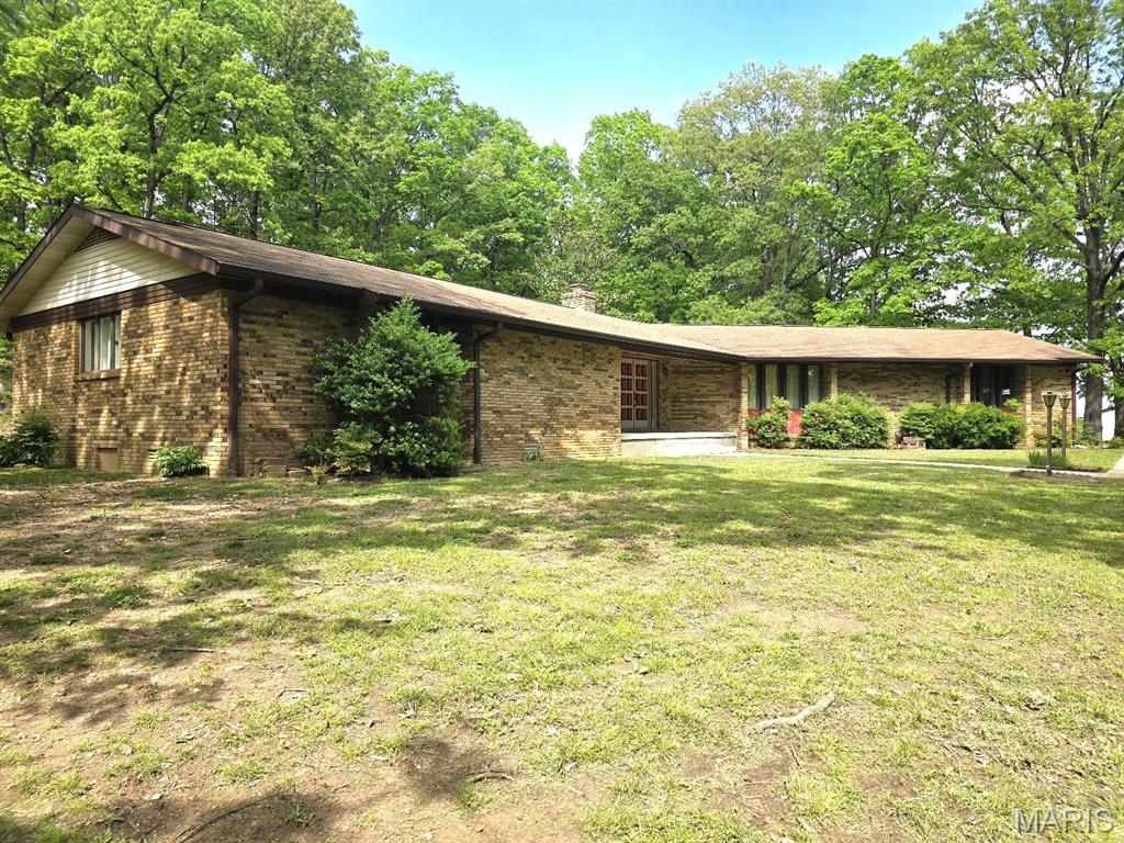 This custom-built, one-owner home sitting on 1.59 acres, m/l in a serene location, is ready for new owners. 3-bedrooms, 2 full bathrooms and one 3/4 bathroom. This home has a ton of storage. You will love all of the closet space. The hallway has multiple closets for all of your linens and extra clothing. Additional closets in the laundry area and a linen closet in the 3/4 bath. Walk-in closets in each bedroom. You may need more stuff for all of the storage areas! Brand new flooring in Living Room, Dining Room, Kitchen, Family Room, and laundry area. Primary en suite includes a vanity with a covered bench. An attached, 2-car garage also has storage available. This home is built upon a hill, so you are surrounded by trees on all sides, and you feel as though you are in the wilderness although you are only a few minutes from town located on a paved road. Want to escape and enjoy the outside? You have 2 covered porches and a sunroom. Kitchen appliances & washer & dryer stay.