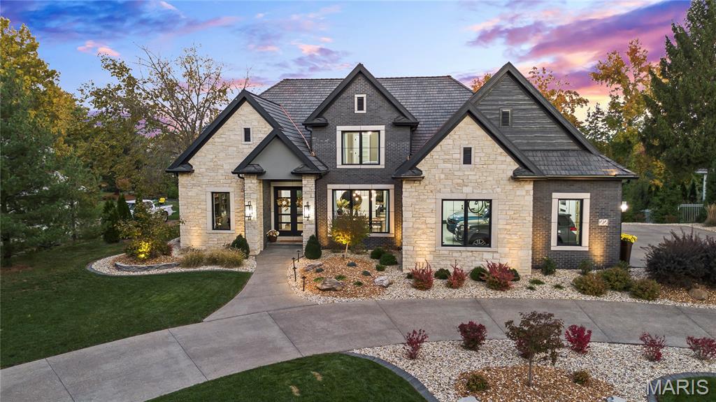 Welcome to 22 Southbridge Ln, a rare opportunity to own one of the most custom and luxurious homes in Edwardsville’s prestigious Stonebridge subdivision. Newer construction, built in 2022, and perfectly situated on nearly an acre, this estate blends timeless sophistication, advanced technology, and impeccable craftsmanship. From the moment you enter, the quality is unmistakable. The main level showcases wide-plank engineered hardwood floors, architectural ceilings, designer lighting, and a spacious open floor plan. The chef’s kitchen features custom cabinetry, an oversized island, and a high-end Dacor appliance package, all finished with exceptional detail. Adjacent to the kitchen is a formal dining room, ideal for entertaining, and a dedicated office with custom built-ins, providing a refined workspace that complements today’s lifestyle. The primary suite offers a true spa-like retreat with heated bathroom floors, heated shower floor, and a heated towel rack, along with peaceful views overlooking the backyard and pool area. Upstairs, you’ll find two large bedrooms connected by a stylish Jack-and-Jill bathroom, plus a versatile loft area perfect for a study nook, playroom, or additional lounge space—providing flexibility for family and guests. The finished lower level is built for entertainment and leisure, featuring a theater area, full bar, and immersive audio system. Hidden design elements elevate the space: a custom bookshelf conceals the home’s advanced mechanicals—including the HVAC, ERV, and scent diffusion system—while another hidden door leads to a private storage area and a reinforced safe room that is both tornado- and fire-rated. Behind the luxury finishes lies a foundation of engineering excellence. The home is equipped with 400-amp electrical service, a full-house generator with automatic transfer switch, whole-house water filtration system with app-monitored flow, dual backup sump pumps, dual water supply, steam humidifier, and MERV-16 air filtration for unmatched comfort and air quality. Every system was selected for reliability, efficiency, and long-term performance. The outdoor living space is truly resort-caliber. The four-layer anti-slip patio, covered entertaining area, and luxury outdoor kitchen complete the backyard oasis—featuring a hybrid grill, built-in refrigerator, generous counter space, and integrated lighting. Whether hosting a party or enjoying a quiet evening poolside, this outdoor space is second to none. Built with precision, maintained with care, and finished to perfection, 22 Southbridge Lane stands as one of Edwardsville’s most impressive residences. With unmatched quality, innovative systems, and exquisite design throughout, this home defines modern luxury living.