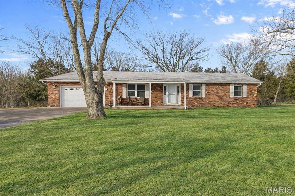 This inviting 3-bedroom, 2-bath ranch sits on 2 peaceful acres, offering a thoughtful blend of character, comfort, and functionality. Perfectly positioned to enjoy the best of Farmington and Park Hills while embracing the serenity of rural living, this home feels both private and convenient. Outdoors, a fully fenced backyard and expansive covered deck create a secluded retreat ideal for quiet evenings or effortless entertaining. Inside, natural light fills the living room, enhancing its warm and timeless appeal. A well-appointed laundry and mudroom seamlessly connects the two-car garage to the kitchen and dining area, adding ease to everyday living. Designed for comfort and connection, this home delivers an atmosphere of warmth, style, and charm.