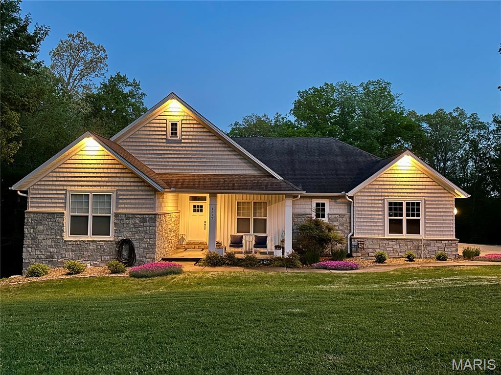 This beautiful custom-built home offers the rare combination of privacy, character, and convenience — all tucked away on 1.5 acres in the middle of town with a wooded backdrop that makes it feel like country living. Full of charm and detailed craftsmanship throughout, this one-of-a-kind property was thoughtfully designed with both everyday living and entertaining in mind.
The main level features 3 bedrooms, 2.5 bathrooms, a dedicated office space, and a true laundry room. Warm, inviting living spaces are complemented by custom trim work, beautiful finishes, built ins, and timeless style throughout the home. The full walkout basement adds incredible additional living space with 2 dedicated bedrooms, a full bathroom, a cozy fireplace, bar area, and a massive unfinished storage space with endless possibilities.  Step outside to the screened-in back porch overlooking the wooded backdrop and private backyard setting — offering the peaceful feel of country living while still being conveniently located in town.