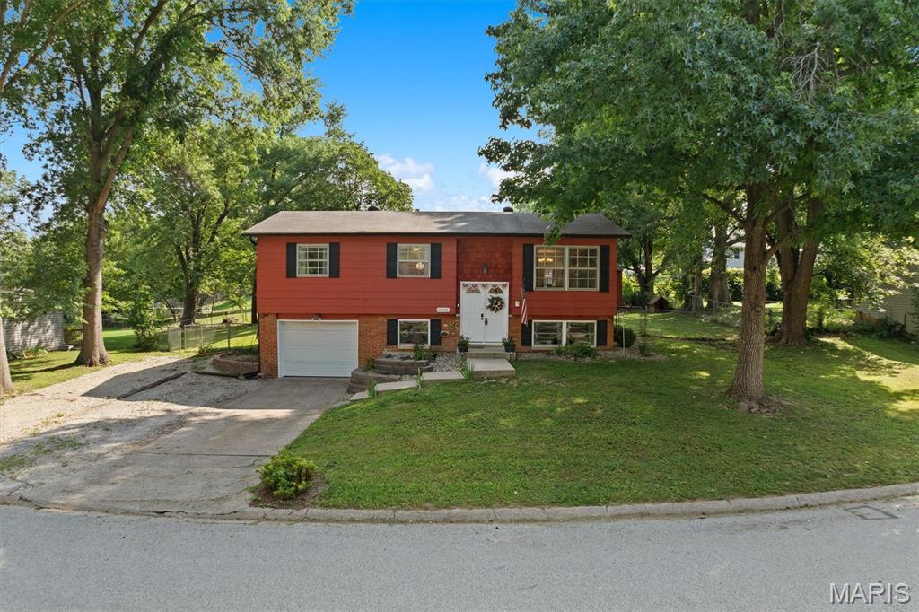 Charming split-level home in Piasa Hills neighborhood features 4 bedrooms and 2 baths. The updated kitchen offers newer appliances, ceramic tile floors, and newer lower cabinets.  The living room offers beautiful hardwood floors that extend to the dining room and throughout the main level adding warmth and charm. Downstairs you'll find a spacious family room along with a 4th bedroom. Step outside to enjoy the above-ground pool with a new liner and fenced in yard, perfect for relaxing or entertaining complete with a single car garage for added convenience. This home blends comfort, style, and a great location.  Perfect for entertaining inside and out! ***Please see list of updates under disclosures.*** Exclusions:  Rose bush at the front corner of the driveway, small lavender bush on left side of house, and small hydrangea at the right front corner of the property.