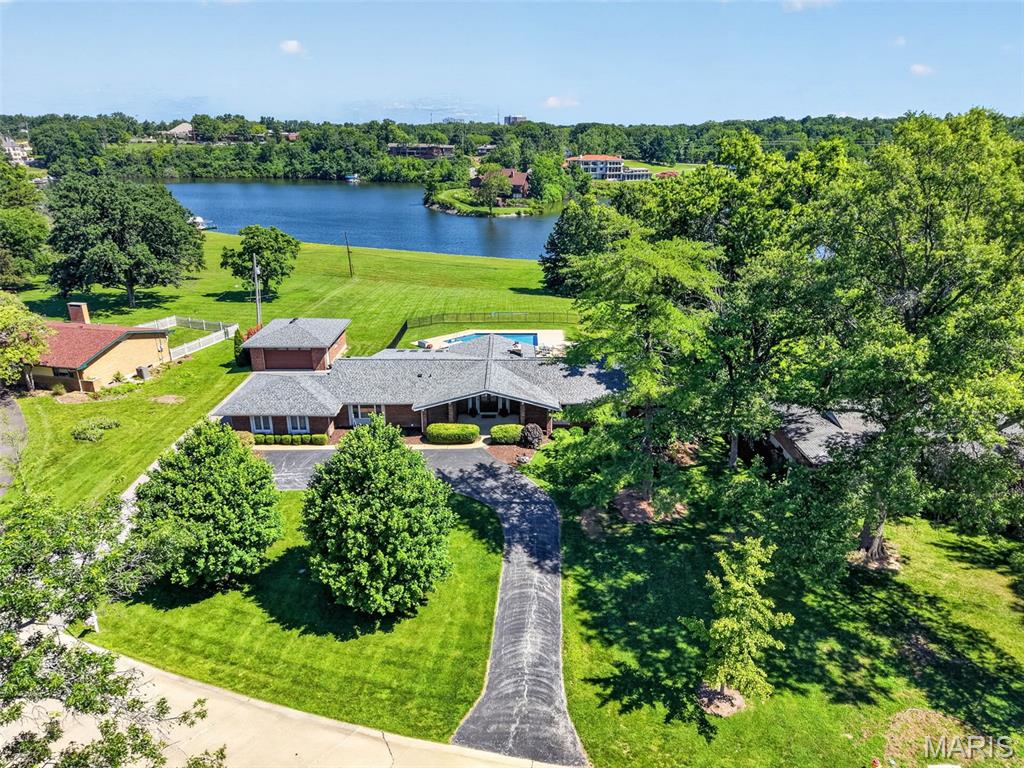 Vacation-at-home living meets an unbeatable central location in this one-of-a-kind lakefront retreat! Nestled on a gorgeous 1.2 acre lot backing to Westchester Estates' private lake, this exceptional ranch in Creve Coeur offers a rare combination of privacy, recreation & an amazing location with its close proximity to Highways 270 and 40/64. Enjoy fishing, boating or waterskiing on the lake or relax and enjoy the view of the lake from your backyard featuring an inground saltwater pool. To house all your cars and water toys, you will love the oversized 2-car attached garage PLUS the 30' deep detached garage with room for 2 additional cars and a boat. Inside, the home blends warmth, upscale finishes & wonderful natural light. The vaulted great room features hardwood flooring, 2 sets of atrium doors opening to the backyard oasis and a gorgeous tongue-and-groove ceiling with exposed beams and abundant recessed lighting. The center island kitchen boasts gorgeous Amish cabinetry, granite countertops, stainless steel appliances including a 5-burner gas stove, a stone backsplash, ceramic tile floors, a large adjoining breakfast room & a slider door to the sunroom. Hardwood flooring continues through the hallway and bedrooms, including into the spacious primary suite with its large walk-in closet featuring custom built-ins and a center island plus a beautifully renovated bathroom with heated tile floors, double bowl vanity & an oversized dual-head shower with gorgeous tile work. The hall bath that services the 2 ancillary bedrooms (both with nice-size walk-in closets) is fabulous, too, and features heated tile floors, a double bowl vanity & a zero threshold shower.  Completing the main floor are the laundry room and a 16' x 12' flex room with hardwood floors that could be converted back to a bedroom with the addition of a closet or used as a living room, dining room or home office. The finished lower level features a large rec room, another remodeled full bath with heated floors & designer tile work, an exercise room & an extra room that could be used as an office, playroom or sleeping area. The zoned HVAC and water heater were replaced in 2023, the front door & adjacent windows in 2025 and a new roof was installed just last week! This is more than a home—it’s a rare lifestyle opportunity in the heart of St. Louis!