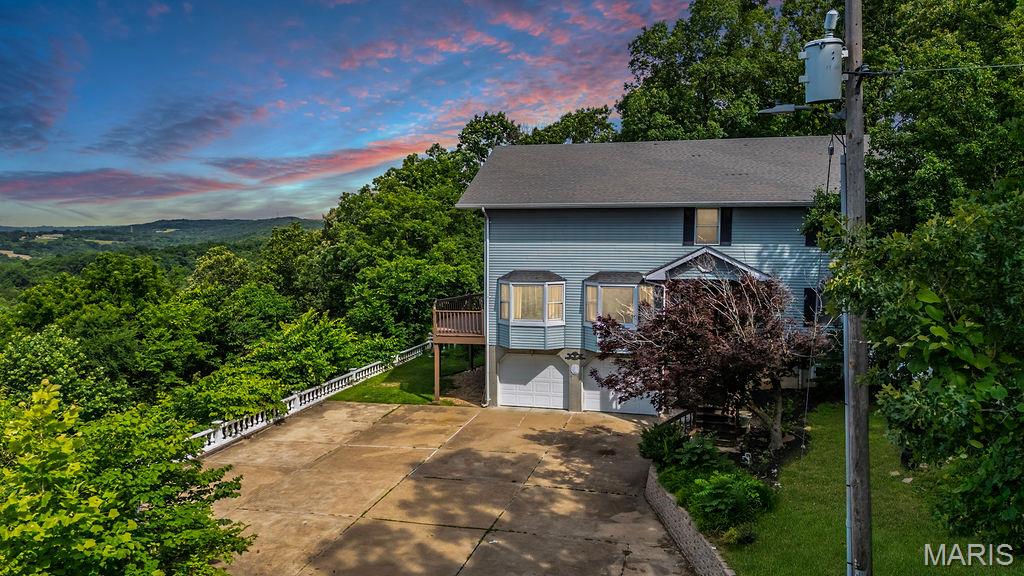 One-of-a-Kind Opportunity! Nestled on 2 private acres, this extraordinary 3-story home offers 4,000 sq. ft. of living space and breathtaking, million-dollar views without the million-dollar price tag. The show-stopping great room features soaring ceilings and walls of windows that frame the stunning scenery, with direct access to an expansive deck perfect for entertaining or simply soaking in the view.
The second level offers two guest bedrooms, a full bath, and a spacious kitchen with breakfast bar that opens to the inviting family room, complete with a stone-surround wood-burning fireplace. An all-seasons sunroom extends the living space and provides additional access to the deck and panoramic vistas.
Retreat to the entire third-floor primary suite, accessed through grand double doors. A loft overlooking the great room creates the perfect reading nook, office, or sitting area while capturing even more of the spectacular views. The oversized walk-in closet, spacious bath with double vanity, abundant storage, and private covered deck make this owner’s retreat truly exceptional—the ideal place for morning coffee, birdwatching, and enjoying the peaceful seclusion.
The attached oversized 2-car garage is complemented by a versatile main-level living area featuring its own kitchen, full bath, and laundry, offering endless possibilities as an in-law suite, home office, guest quarters, or ultimate entertaining space.
Being sold as-is, with a 1-year home warranty provided by the seller for added peace of mind. Here’s your chance to transform this truly unique property into the dream home you’ve always envisioned. Opportunities like this don’t come around often!