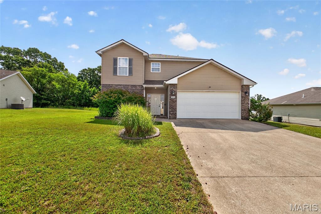 Immediate peace of mind awaits with this meticulously maintained, one-owner 3-bedroom, 2.5-bath home located within the city limits of Waynesville and just minutes from the West Gate of Fort Leonard Wood. If you've been searching for a truly move-in ready home with the major expenses already taken care of, this is it! Recent updates include a GAF Certified roof with warranty (2023), upgraded HVAC system (2022) featuring a larger air handler and higher-efficiency heat pump, larger water heater (2022), and a privacy fence installed in 2024. The sale also includes the washer, dryer, storage shed, and push mower, making your move even easier. Step inside to a welcoming entryway with convenient access to the attached two-car garage and a guest half bath. The spacious living room offers carpeting for comfort and abundant natural light from three large windows overlooking the fully fenced backyard. The adjoining kitchen and dining area features beautiful light oak cabinetry, laminate countertop space, white appliances, a breakfast bar, and plenty of room for everyday meals or entertaining. Sliding glass doors lead to the backyard patio and privacy fenced yard, perfect for pets, kids, or hosting family and friends.
Upstairs, you'll find a spacious primary suite complete with an ensuite bathroom offering double sinks, an oversized vanity, a tub/shower combination, and a large walk-in closet. Two additional carpeted bedrooms, a full guest bathroom, and an upstairs laundry room add to the home's thoughtful and functional layout. With every major system already updated and a level of care that's evident throughout, this home offers the perfect combination of comfort, value, and peace of mind. Don't miss your opportunity to make it yours—schedule your private showing today!