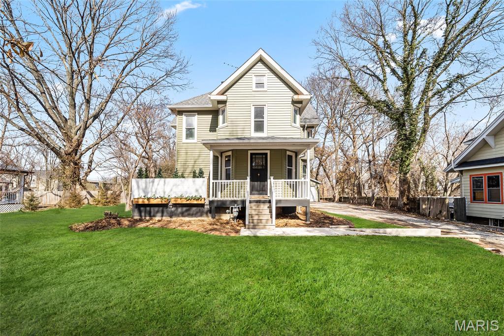 Located within walking distance of downtown Edwardsville, this extensively renovated residence has been transformed from top to bottom, offering the style, systems, and craftsmanship of new construction while preserving its timeless character. Originally a 4-bedroom, 2-bath home, the thoughtfully redesigned layout now features 5 bedrooms and 3.5 bathrooms, including two ensuite bedrooms—one on each level. The heart of the home is the beautifully redesigned kitchen, where quartz countertops, updated cabinetry, new appliances, and a stylish backsplash flow seamlessly into the light-filled vaulted family room—creating an ideal space for both everyday living and entertaining. A main-level stackable laundry area within the primary suite closet adds convenience, with an additional washer and dryer hookup available in an upstairs bedroom for added flexibility. Full bathrooms showcase custom-tiled showers and quartz-topped vanities. Significant upgrades include a newer roof, all new plumbing, tankless water heater, upgraded electrical panel and wiring, updated lighting, flooring, paint, plaster walls, some interior doors, exterior doors, and a redesigned staircase. The home features two high-efficiency gas furnaces and two high-efficiency air conditioning units serving the main level, along with a new furnace and air conditioning system on the upper level—providing efficient zoned comfort throughout. A radon mitigation system has also been installed for added peace of mind. Exterior improvements include new siding and downspouts, composite front and side porches, and a newly constructed oversized 24’ x 26’ garage with 10’ doors with a separate attached workshop. Situated on approximately a half-acre lot, the backyard offers a peaceful setting with open views and frequent wildlife sightings—providing a quiet, scenic backdrop while remaining just minutes from downtown amenities. A truly one-of-a-kind property offering exceptional space, quality, and modern comfort in one of Edwardsville’s most desirable locations.