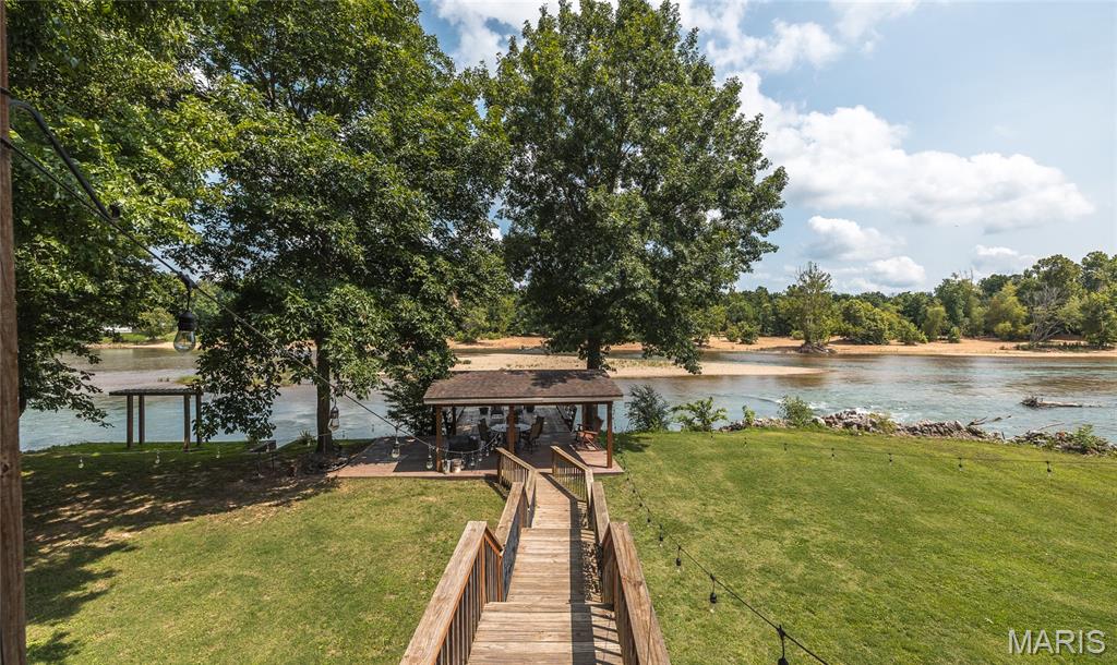 A rare opportunity on the world-famous Current River! This exceptional riverfront estate combines luxury living, outstanding recreational amenities, and proven income potential in one remarkable property. Boasting nearly 600 feet of Current River frontage on 3 more or less secluded acres at the end of a private road, this is a one-of-a-kind offering in one of southeast Missouri's most desirable river destinations.

The impressive 4-bedroom, 3-bath main home offers nearly 3,000 square feet of beautifully designed living space with an open-concept floor plan that's perfect for entertaining. The gourmet kitchen features a large double commercial refrigerator, abundant workspace, and everything a home chef could want. The spacious primary suite includes generous closet space and a luxurious en-suite bath with a soaking tub and separate shower.

Step outside to expansive outdoor living spaces where you can relax on the deck overlooking the river or follow the boardwalk to a covered riverside deck perched just above the water's edge—the perfect place to enjoy breathtaking views, fish, or simply unwind. 

Beyond the main residence, the property includes a versatile 40' x 40' heated and cooled shop with living quarters, offering endless possibilities for guests, hobbies, storage, or additional living space. An adjacent pavilion creates the ideal setting for family gatherings, celebrations, and outdoor entertaining. The property also includes your own boat ramp.

Adding even more value are three additional cabins currently operating as successful short-term rentals, providing immediate income potential while allowing plenty of space for family and friends. Whether you continue the thriving vacation rental business, create your own private family compound, or enjoy the best of both worlds, this property offers exceptional flexibility and investment opportunity.

Whether you're searching for a luxury riverfront residence, an established vacation rental business, or a premier recreational retreat, this extraordinary Current River property delivers unmatched beauty, privacy, lifestyle, and income potential in one unforgettable package. Call today to schedule your own private tour.