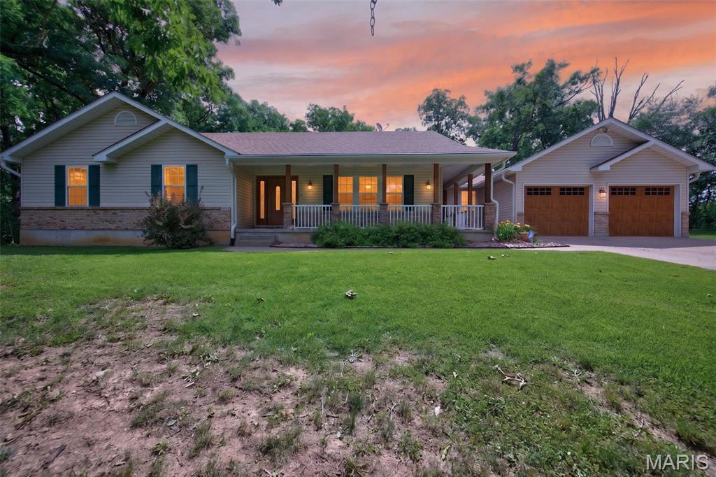 Peaceful country living meets convenience just 5 minutes from Troy. Situated on nearly 2.5 wooded acres, this exceptionally clean and well-maintained home offers over 1,800 square feet on the main level with a desirable split-bedroom floor plan designed for privacy. The spacious main floor features 3 bedrooms (all with walk-in closets), 2 full bathrooms and main floor laundry with enclosed breezeway to the garage. The large kitchen with granite countertops, an island and abundant cabinet space is highlighted by a dining area and beautiful bay window that brings in natural light. Step outside and enjoy the incredible outdoor setting complete with mature trees--including two pear trees and a blueberry tree, an above-ground pool, professional landscaping and a brand-new deck/gazebo. Approximately half an acre is fenced, providing plenty of space for pets, play or gardening. The side walkout lower level offers exceptional flexibility with a sleeping room with a walk-in closet, full bathroom, full kitchen and living room—perfect for guests, entertaining or multi-generational living. Additional features include a new geothermal furnace system for energy efficiency, new AC, newer water heater, leaf guard gutters, newer carpet throughout, new exterior doors, a 2-car oversized attached garage that's finished and provides a man-door to the backyard and a detached 1-car garage. With the privacy of nearly 2.5 wooded acres, this combination of space, functionality and location are hard to find!