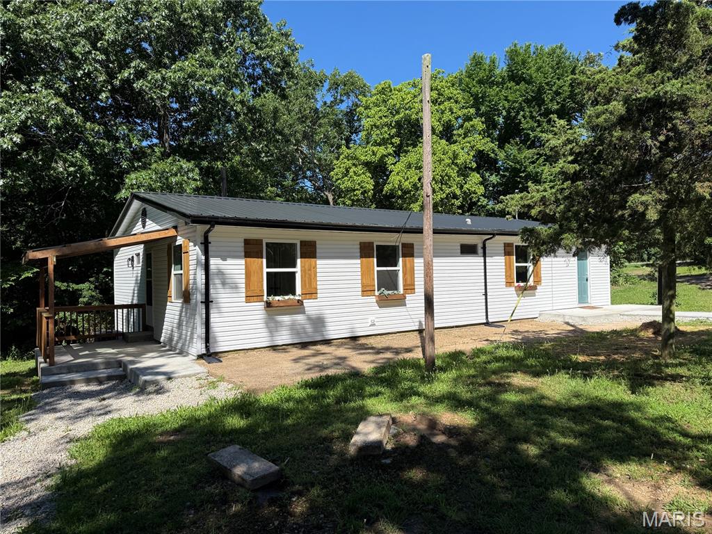 Welcome to 21700 Hwy Y in St. Robert — a beautifully remodeled 4-bedroom, 2-bathroom home tucked away in a quiet wooded setting offering the perfect blend of modern updates and rustic charm. This move-in ready property features brand-new exterior siding and energy efficient windows, a new roof, all new luxury vinyl plank flooring throughout, and a new HVAC system for peace of mind. The updated kitchen showcases stunning butcherblock countertops, stainless steel appliances, and stylish finishes, while exposed wood beams add warmth and character to the living space. Enjoy relaxing on the covered side porch overlooking the serene surroundings. The oversized detached garage/workshop provides ample space for vehicles, storage, hobbies, or projects. With thoughtful upgrades inside and out, this property offers comfort, functionality, and privacy all in one exceptional package.