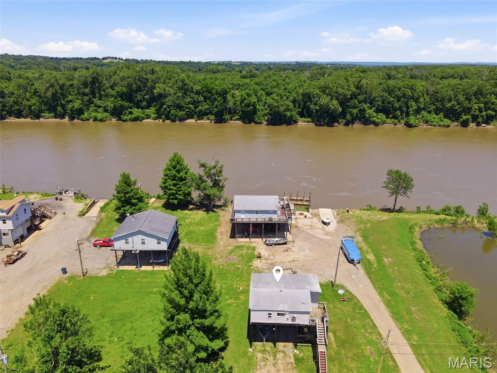 RIVER LIFE! Full time or Weekend Get Away. Rare opportunity to own one of the highly sought-after RIVERVIEW lots with a 1 Bed Clubhouse with front and back deck in The Dardenne Slough on Pool 26 of The Mississippi River! Also, this is one of the few developments where you own your land, the Army Corp. has no ownership! Enjoy breathtaking vistas of the majestic Mississippi River right from your private deck and Check out the neighboring covered decks under the homes that would offer another level of outdoor living!  View of the private pond that hosts families of ducks and calming views off the back deck.  Home has an open floor plan with room to enclose more space, possibly 2nd Bedroom/4 Season Room on riverside deck & is equipped with full electric heating, cooling, and appliances to ensure year-round comfort! Newer Roof! Room to park 2 vehicles/boats under the home. Whether you're seeking a weekend retreat, a peaceful home office, or a full time residence, this cabin offers a unique opportunity to live close to nature without sacrificing modern amenities. Home hasnt had water inside since '93 after it was raised. (Elevation Letter in The MLS Supplements) Shallow Well & Septic serve the home. (neighbor installing a Compost Disposal System, affordable option for sewer.) Sits on a private road, 10 min-to HWY 70, 370, New Town or take a boat ride for eats/drinks/entertainment.  Ramp and Dock are not part of this property. Sold as-is.  Buyer responsible for all inspections. Taxes $663. Please have Proof of Funds letter/pre-approval for loan in hand.