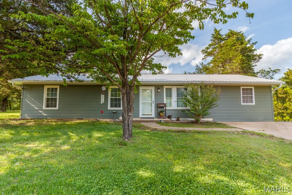 This gorgeous 4 bedroom/ 2 bath home is filled with upgrades galore!  It's been totally remodeled inside and out to include new LVP flooring throughout, a new metal roof with guttering, HVAC system with heat pump and an updated electrical system and breaker box. All new plumbing and a water softener have been installed as well.  As you walk in the front door you are greeted with an open concept floor plan that draws attention to the state-of-the-art kitchen.  It is beautifully designed to include a touch free sink, quartz countertops, soft closing custom cabinets and an oversized island all great for your entertainment needs. This home also features a beautiful primary suite with a spa-like bathroom to include a clawfoot, soaking tub, a rainfall shower, LED mirror with a custom cabinet for your make up and so much more.  Located on a huge double lot surrounded by trees and a nice level yard, close to restaurants and shopping and not far from the front gate of Fort Leonard Wood. You couldn't ask for more.  Don't let this one get away.  Schedule your appointment today!