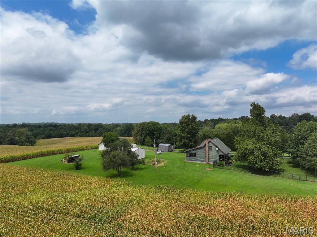 Tucked away at the end of a private lane just outside of Jackson/Fruitland, this one-of-a-kind property offers the peace and privacy of country living while keeping you just minutes from everything Jackson, Cape Girardeau, and Fruitland have to offer. Surrounded by picturesque crop fields, the setting feels miles away from anyone and anything, yet everyday conveniences are still close at hand.

Situated on 101.99± acres, the property features a comfortable 3-bedroom, 2-full-bath 1,733 sq. ft. home with an attached 2-car garage. Additional improvements include a detached shop/garage with heating and cooling, plus another outbuilding providing even more space for equipment, storage, hobbies, or recreational gear.

The outdoor spaces are where this property truly shines. Relax on the screened-in porch and take in the peaceful surroundings and expansive country views, or spend an afternoon on the inviting front porch beneath mature shade trees. A beautifully fenced front yard provides a great space for pets to enjoy the outdoors, while mature apple trees add even more character and country charm to the property.

In addition to the privacy and acreage, the productive crop ground offers the potential for continued farm rental income without the new owner having to farm the property themselves. The crop fields are currently leased through the end of the year, providing an established agricultural use with the opportunity for the new owner to explore continuing a farm lease in the future.

With over 100 acres, productive farmland, multiple outbuildings, mature fruit trees, abundant privacy, and an incredibly convenient location, this property offers a rare combination of country living, usable acreage, and income potential. Whether you're looking for a private residence, room to spread out, an investment component, or simply a place where you can slow down and enjoy the scenery, this property deserves a closer look.