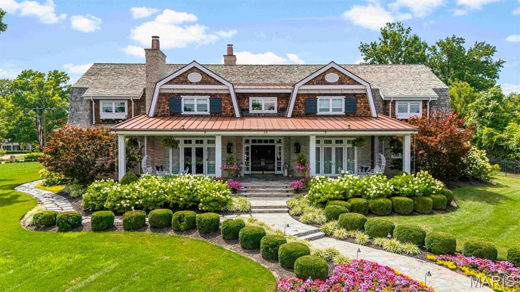 A rare opportunity, Architectural and Design Award winning home, including the 10 MOST BEAUTIFUL HOMES in St. Louis. Welcome to 39 Countryside Lane, an extraordinary Dutch Colonial nestled within one of St. Louis' most coveted neighborhoods. Architecturally significant yet effortlessly at home among the distinguished residences that line this treasured lane, the property evokes the timeless elegance of the Hamptons and Nantucket while offering a lifestyle uniquely its own. From the moment of arrival, the expansive front porch, meticulously curated landscaping, and exceptional craftsmanship hint at the remarkable experience that awaits within.

A gracious foyer introduces the home's sophisticated interiors, opening to a grand dining room featuring by a temperature-controlled wine room—an unforgettable setting for both intimate gatherings and large-scale entertaining. French doors invite guests onto the sweeping front porch, where evenings naturally linger long after dinner has ended.

At the heart of the home, the breathtaking great room is framed by soaring ceilings and walls of glass that bathe the space in natural light while creating a seamless connection to the outdoor living areas, pool, and beautifully landscaped grounds. One of five fireplaces found throughout the home adds warmth and character to this spectacular gathering space.

The kitchen is nothing short of a culinary masterpiece, thoughtfully designed for both everyday living and elevated entertaining. Anchored by a stunning La Cornue range, it is complemented by Miele coffee makers and dishwashers, Wolf and Sub-Zero appliances, Kohler Karbon faucets, and an array of bespoke details. A butler's pantry, complete with one of the home's charming library ladders, a walk-in pantry, and a spacious laundry room provide both beauty and functionality. The main level also offers two powder rooms, an elevator, access to the outdoor living spaces, two attached garages, the primary suite, and an exceptional pool house.

The primary suite serves as a serene private retreat, featuring an expansive custom closet, a spa-inspired bath, and direct access to a versatile art studio and pool house. Complete with its own kitchen, laundry, and full bath, this remarkable space offers endless possibilities for guests, creative pursuits, or effortless indoor-outdoor entertaining.

Upstairs, a stunning library loft lined with three walls of custom built-ins creates a warm and inviting gathering space. Three generously sized ensuite bedrooms, each with beautifully appointed baths and exceptional closet space, complete the upper level.

The lower level rivals the finest luxury resorts, thoughtfully designed as a private wellness retreat. Featuring dedicated fitness space, a recreation room, and a sophisticated bar area, it offers the perfect balance of relaxation, entertainment, and everyday enjoyment.

Charming, sophisticated, and impeccably executed, 39 Countryside Lane represents a rare opportunity to own one of St. Louis' most exceptional residences—a home where timeless architecture, extraordinary craftsmanship, and effortless livability come together in perfect harmony.