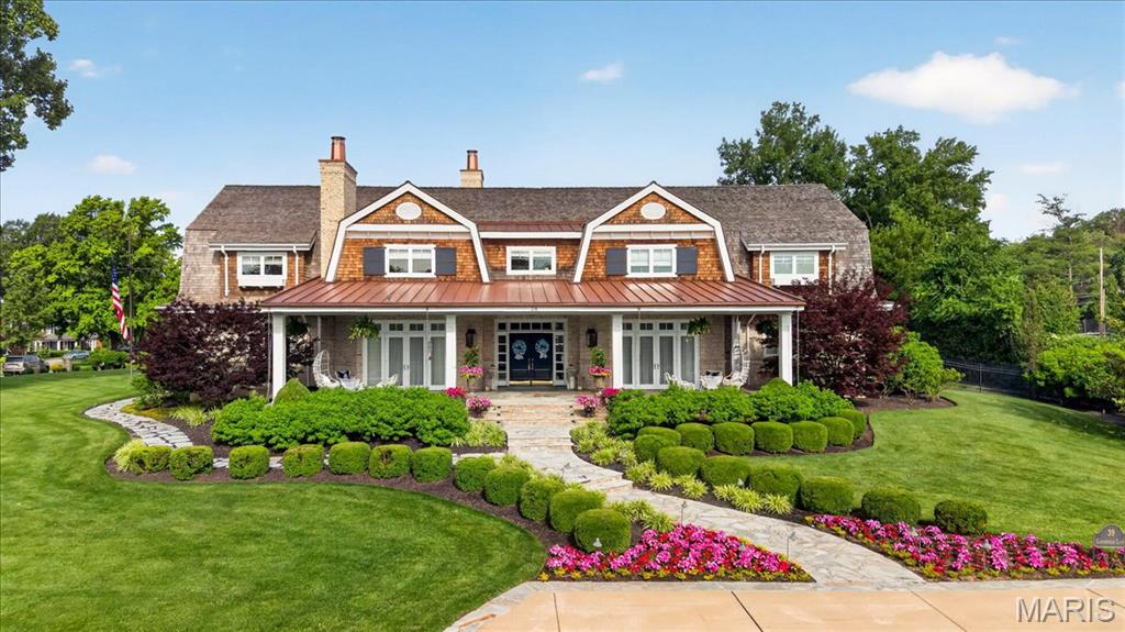 A rare opportunity, Architectural and Design Award winning home, including the 10 MOST BEAUTIFUL HOMES in St. Louis. Welcome to 39 Countryside Lane, an extraordinary Dutch Colonial nestled within one of St. Louis' most coveted neighborhoods. Architecturally significant yet effortlessly at home among the distinguished residences that line this treasured lane, the property evokes the timeless elegance of the Hamptons and Nantucket while offering a lifestyle uniquely its own. From the moment of arrival, the expansive front porch, meticulously curated landscaping, and exceptional craftsmanship hint at the remarkable experience that awaits within.

A gracious foyer introduces the home's sophisticated interiors, opening to a grand dining room featuring by a temperature-controlled wine room—an unforgettable setting for both intimate gatherings and large-scale entertaining. French doors invite guests onto the sweeping front porch, where evenings naturally linger long after dinner has ended.

At the heart of the home, the breathtaking great room is framed by soaring ceilings and walls of glass that bathe the space in natural light while creating a seamless connection to the outdoor living areas, pool, and beautifully landscaped grounds. One of five fireplaces found throughout the home adds warmth and character to this spectacular gathering space.

The kitchen is nothing short of a culinary masterpiece, thoughtfully designed for both everyday living and elevated entertaining. Anchored by a stunning La Cornue range, it is complemented by Miele coffee makers and dishwashers, Wolf and Sub-Zero appliances, Kohler Karbon faucets, and an array of bespoke details. A butler's pantry, complete with one of the home's charming library ladders, a walk-in pantry, and a spacious laundry room provide both beauty and functionality. The main level also offers two powder rooms, an elevator, access to the outdoor living spaces, two attached garages, the primary suite, and an exceptional pool house.

The primary suite serves as a serene private retreat, featuring an expansive custom closet, a spa-inspired bath, and direct access to a versatile art studio and pool house. Complete with its own kitchen, laundry, and full bath, this remarkable space offers endless possibilities for guests, creative pursuits, or effortless indoor-outdoor entertaining.

Upstairs, a stunning library loft lined with three walls of custom built-ins creates a warm and inviting gathering space. Three generously sized ensuite bedrooms, each with beautifully appointed baths and exceptional closet space, complete the upper level.

The lower level rivals the finest luxury resorts, thoughtfully designed as a private wellness retreat. Featuring dedicated fitness space, a recreation room, and a sophisticated bar area, it offers the perfect balance of relaxation, entertainment, and everyday enjoyment.

Charming, sophisticated, and impeccably executed, 39 Countryside Lane represents a rare opportunity to own one of St. Louis' most exceptional residences—a home where timeless architecture, extraordinary craftsmanship, and effortless livability come together in perfect harmony.