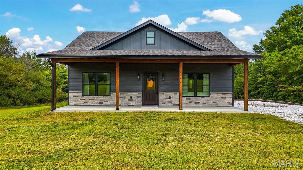 Built in 2025 and situated on 5 surveyed acres, this beautiful home offers the perfect combination of privacy, modern finishes, and proximity to Mark Twain Lake! Located just two doors down from Big Larry's Campground and only about 10 minutes from the Robert E. Allen Boat Ramp, this property is an ideal full-time residence, weekend getaway, or lake destination.

Inside, you'll find warm stained wood accents throughout the living room and kitchen, including a stunning floor-to-ceiling stone electric fireplace. The kitchen features custom cabinetry, live-edge stained butcher block countertops, and stainless steel appliances that convey. A spacious walk-in laundry room provides plenty of additional storage and countertop space.

The home offers 2 bedrooms and 2 full bathrooms, including a primary suite with a walk-in closet and private bath featuring a custom onyx shower. Outside, durable LP SmartSide siding is complemented by covered front and back porches with beautiful stained cedar post-and-beam details and ceiling fans.
With 5 acres, there's plenty of room to enjoy the outdoors now and add a shop or additional storage in the future for boats, jet skis, side-by-sides, campers, and all the toys that come with lake living. The professionally hydroseeded yard and secluded setting make it hard to believe you're less than a mile from Highway 154. Whether you're looking for a peaceful home base or your own Mark Twain Lake retreat, this one is ready for you!