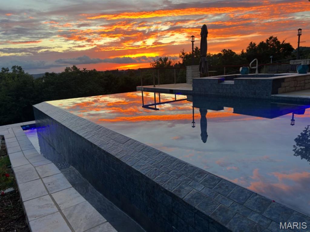 An irreplaceable scenic view with a rare, artfully designed vanishing edge pool/spa combines to make this home a unique and beautiful place where family and friends will WANT to visit and you can enjoy every day. Combine these with a large, beautiful and functional house - which is competitively priced – with bathrooms for every bedroom and two half baths, making entertaining guests/family seamless. For convenience, it’s 10 minutes to Branson. The property is located in the gated community of Emerald Pointe which offers substantial amenities, including pickleball/tennis courts, high & dry storage, docks, and a launch ramp.  Perimeter fencing for security and pets.  Five-car garage with a floored attic above, plus a charger for your EV or RV—features not commonly found. The lot next door is also for sale by the same owner for a reasonable extra cost. Combined the two lots are about 1.3 acres adding to privacy. By acting quickly, the home purchaser also has the option to buy a nearby third party boat slip and lift for additional $$s. The pool, the view, the timeless setting, combined with the attractive, well-appointed and maintained home create an environment where you, your family and guests, will want to be. The seller will pay the buyer's allowable closing costs up to $50k for contracting to purchase by 5/15/26, resulting in possible significant savings with points buying down interest rate.