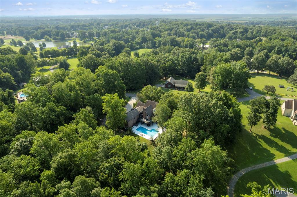 3-acre wooded lot • Inground pool • Detached garage with workshop • Main-level living • Birch hardwood floors

Set on 3 wooded acres in a quiet Benton neighborhood, this 1.5-story home offers the ideal mix of space, privacy, and modern comfort. Inside, the main level features an open, functional layout designed for everyday living as well as entertaining. The large living room flows seamlessly into the dining area and kitchen, where granite countertops, a walk-in pantry, and a huge island create a true gathering space. Birch hardwood floors extend throughout the main level, adding warmth and timeless style, while high ceilings enhance the home’s spacious feel.

This home includes 5 bedrooms and 5 full bathrooms, providing flexibility for guests, offices, or multigenerational living. The primary suite is located on the main level for convenience. Also on the main floor is a super cool man cave—an ideal spot for watching the game, relaxing, or hosting friends. 

The finished lower level expands the home’s versatility with an additional living room, bedrooms, bathroom, storage space, a dog bathing station, and a small kitchen area. This level walks out directly to the pool deck, creating a seamless indoor-outdoor connection ideal for entertaining or extended stays.

Step outside to enjoy your private backyard retreat with an inground pool, concrete patio, and wooded backdrop for added privacy. A three-car attached garage provides everyday convenience, while a detached shop adds extra space for storage, a workshop, or hobby use.

Located just minutes from Benton’s center and Interstate 55, this property combines country privacy with neighborhood ease. Experience open living spaces, outdoor enjoyment, and a versatile floor plan—all in one exceptional 3-acre setting.