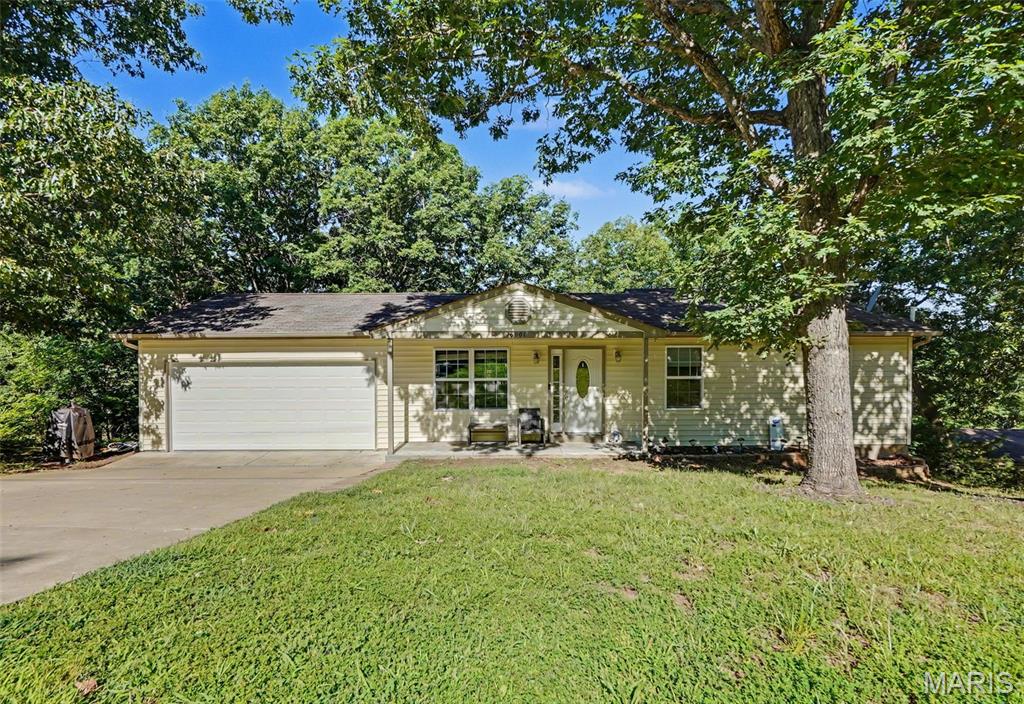 Welcome home to this spacious 4-bedroom, 3-bath ranch nestled on nearly an acre in House Springs! The open-concept main level features a large family room flowing into the dining area and kitchen, complete with a peninsula island offering abundant counter space and cabinetry. The main floor also includes three bedrooms and two full baths. Step outside to the expansive deck—perfect for summer BBQs or relaxing fall evenings overlooking your wooded backyard. The walk-out lower level boasts a generous recreation room, a legal fourth bedroom, a fifth non-conforming bedroom ideal for an office or gym, a full bath, dedicated laundry room, multiple storage areas, and direct backyard access. With no homes across the street, every front window offers peaceful wooded views, providing a sense of privacy and seclusion that's hard to find.