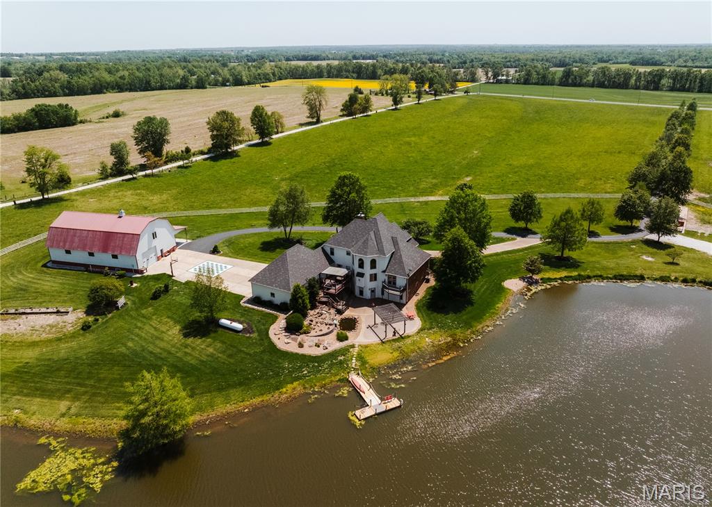 We have the honor & privilege to be bringing to public market the Bickel Estate. They have built this dream literally from the ground up! The custom home overlooks the grounds, offers over 5200 sq.ft. of living space. Mr. Bickel was as Architectural Engineer, ever inch of the home was designed for elegance & entertaining. Pet & smoke free, pride in ownership shines inside & out. Entering the residence you pass thru the 9' mahogany doors into the foyer, to the left is the home office w/views of the front pastures, to the right is the formal dining room. The great room features gas fireplace w/views of the lake w/corner bar. The country kitchen offers stainless steel appliances, center island, silestone-quartz counter tops, bonus cabinet space, breakfast area, & walk in pantry. Main level laundry w/ample space plus guest bath. When you exit the kitchen you'll enter the den w/brick/stone gas fireplace w/views of the hay field. The master suite with his & her closets & master bath w/shower & separate jacuzzi tub. Going upstairs to the landing there is 2 guest bedrooms & 1 full bath. When you go downstairs you enter the living room, guest bedroom(currently sewing room), full bath, billiard room, bar, theater room, wine room & storage room. Attached 4 car garage, multiple entertaining areas including deck & large patio. Professional landscaping w/water fall and Koi pond. The 47 acre m/l estate offers several varieties of trees, hand selected for their unique qualities. The 3 acre m/l stocked lake is beautiful w/large dock to accommodate all the anglers. The majority of the acreage is in pasture/grazing that has over 6,000 linear ft of steel fencing. Assorted paddocks, sorting pens and stalls strong enough for the American Bison. The shop located to the East of the home is 45'x75' with one overhead door, concrete floor, guest room, full bath, well pump room, & lean to. The livestock barn to the Southwest of the home is 44'x72' w/lean to, stalls and paddocks to the South. Places like this don't come available everyday. Blacktop frontage. Southern Lincoln County. Limited deed restrictions. Easy commute to St. Charles County. Shown by appointment only.