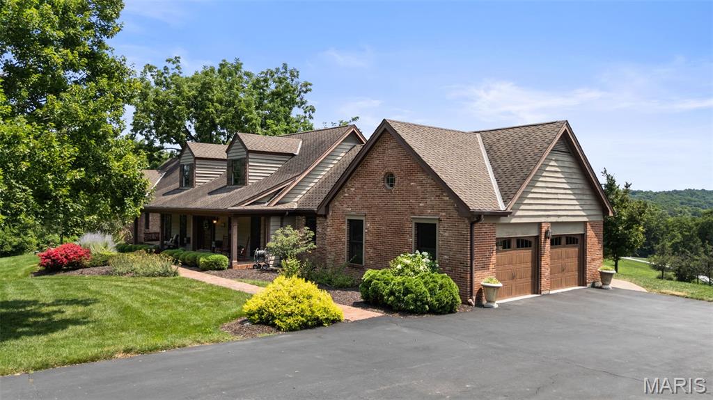 Nestled on three picturesque acres in the heart of Wildwood, this extraordinary custom ranch offers a rare blend of luxury, privacy, and timeless craftsmanship with a designer level mountain lodge aesthetic. Gently rolling grounds, sweeping valley views, and resort-inspired outdoor living create a peaceful retreat just minutes from shopping, dining, and parks. Inside, an open-concept floor plan is anchored by a stunning great room with a soaring timber-beamed cathedral ceiling and a cozy wood-burning fireplace. The chef's kitchen is designed for entertaining with two oversized islands, custom cabinetry, a walk-in pantry, Fulgor Milano induction cooktop, custom copper range hood, double wall ovens, built-in beverage refrigerators, and an ice maker. The thoughtfully designed main level features an expansive primary suite with direct access to a covered patio and hot tub, an additional primary suite plus another guest room, all with full baths.  The first floor also features a full dining room, in-home office, mudroom, and laundry room. Another second-floor office / den provides added privacy, while the finished lower level includes a spacious recreation room, home gym, two additional bedrooms, a full bath, hobby area, and abundant storage. Outdoor living is equally impressive with a covered front porch, expansive patio with stone fireplace and water garden, screened porch, and breathtaking valley views. Oversized attached and detached garages accommodate four vehicles and are complemented by a picturesque red barn outbuilding, offering additional storage and versatility. A truly one-of-a-kind Wildwood property with sweeping views-- don't wait to see this very special luxury retreat!